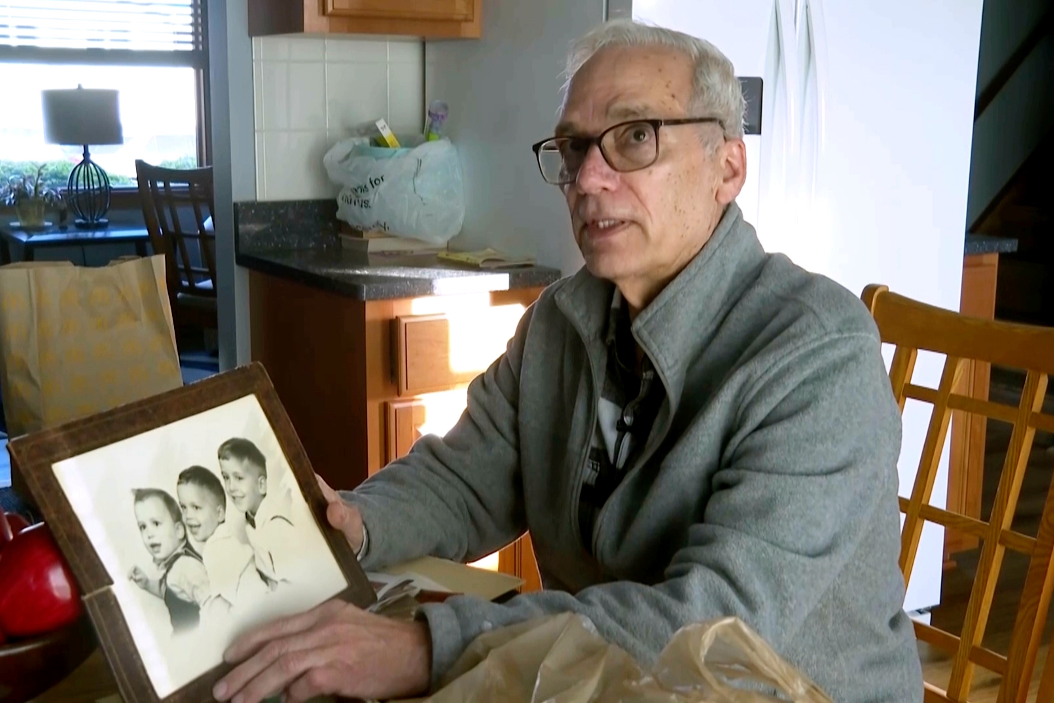 John Prevost, brother of new Pope Leo XIV, holds a portrait of the three Prevost brothers from 1958, Pope Leo, 3, left, John, 4, and Louis, 7, at his home Thursday, May 8