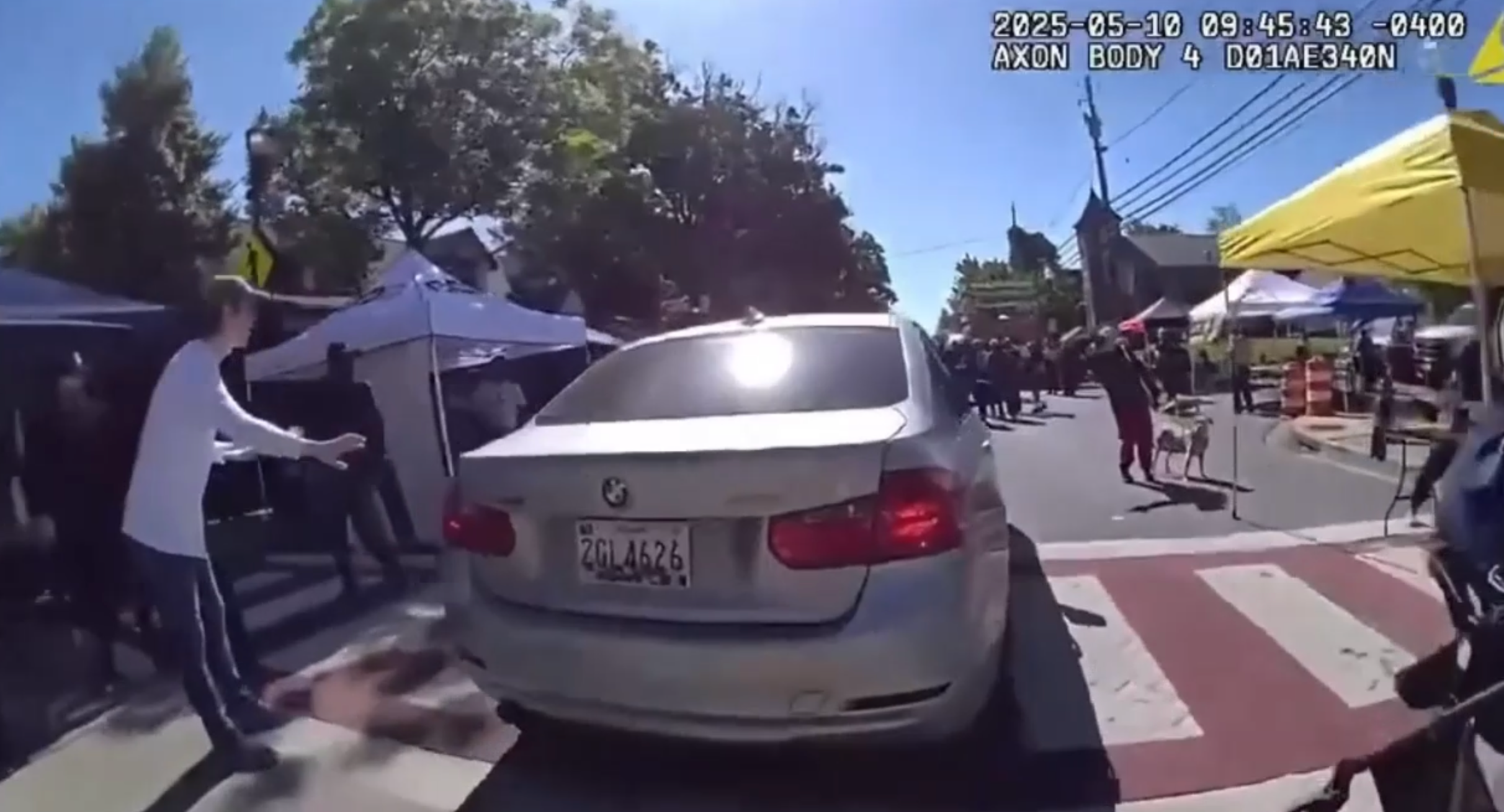 <p>Bizarre moment woman in BMW ignores cop and tries to drive through street festival to get to work</p>