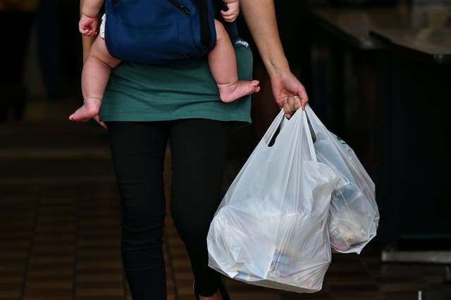<p>Customer carrying plastic bags at a supermarket in Tokyo</p>