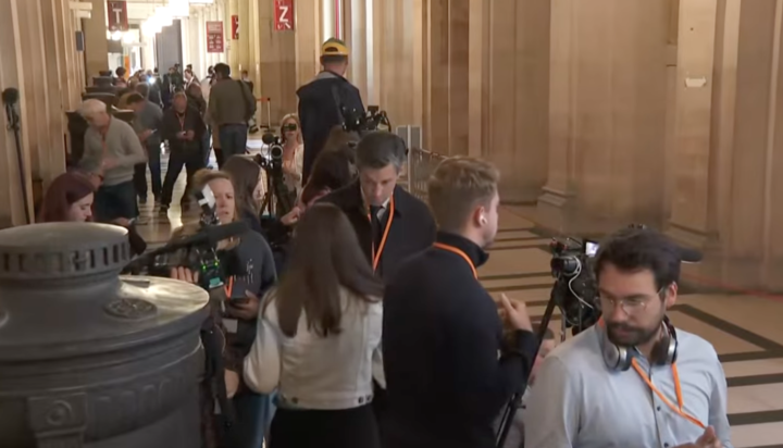 Journalists gather inside the Palais de Justice