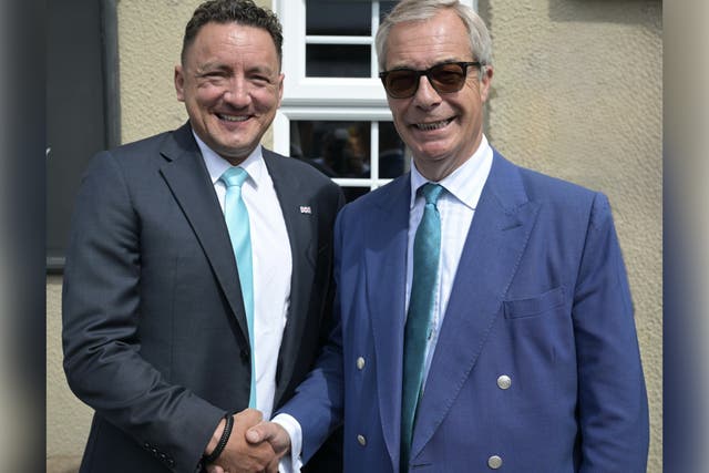 <p>Andrew Hamilton-Gray shakes hands with the leader of Reform UK Nigel Farage</p>