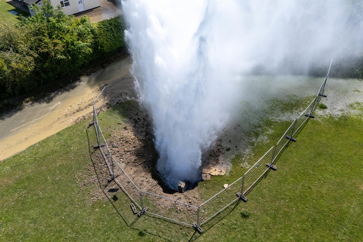 Residential street flooded as burst main shoots 100ft jet of water into the air