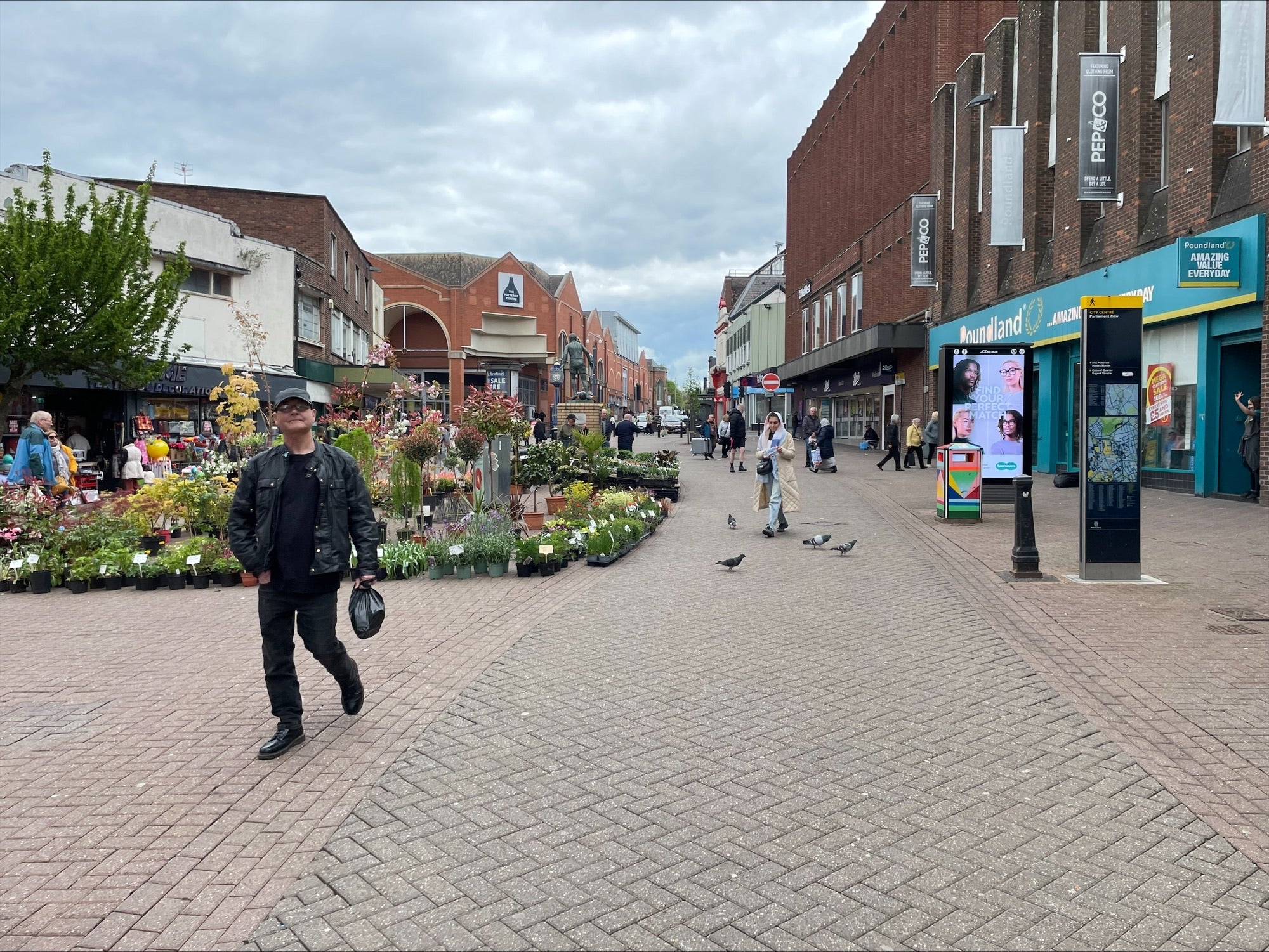 Flowers are sold underneath a Stanley Matthews statue in Hanley, the commercial hub of Stoke-on-Trent - although city leaders say more needs to be done to improve the area impacted by high shop vacancy rates (The Independent)