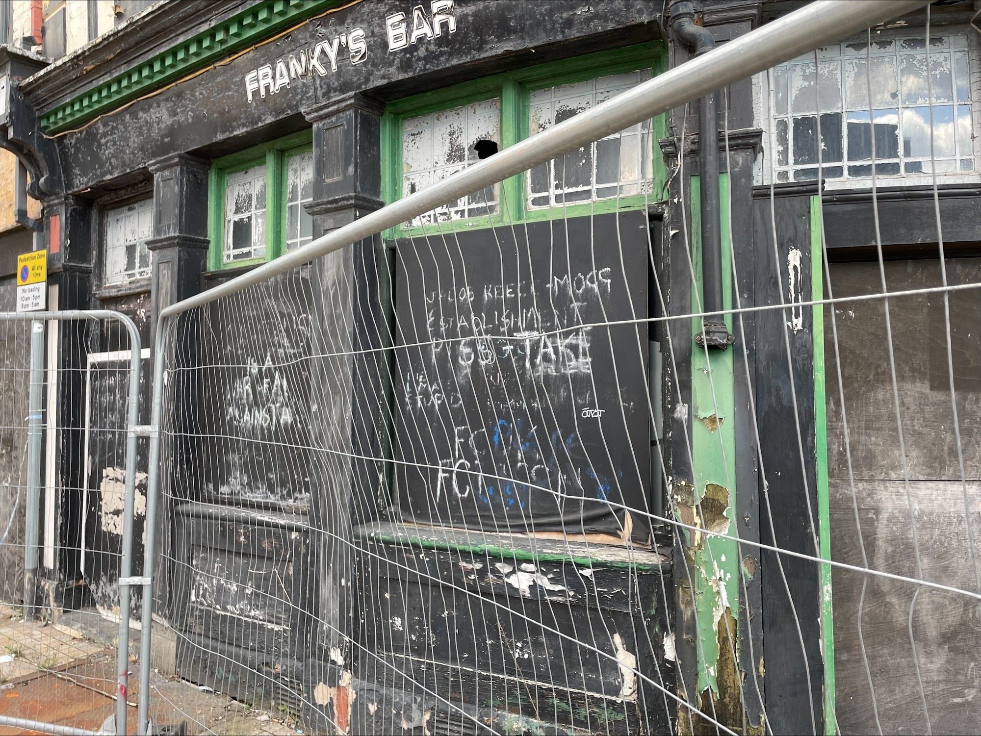 Graffiti directed at Jacob Rees-Mogg and the 'establishment' is scrawled across a dilapidated pub opposite the Etruscan Square development (The Independent)