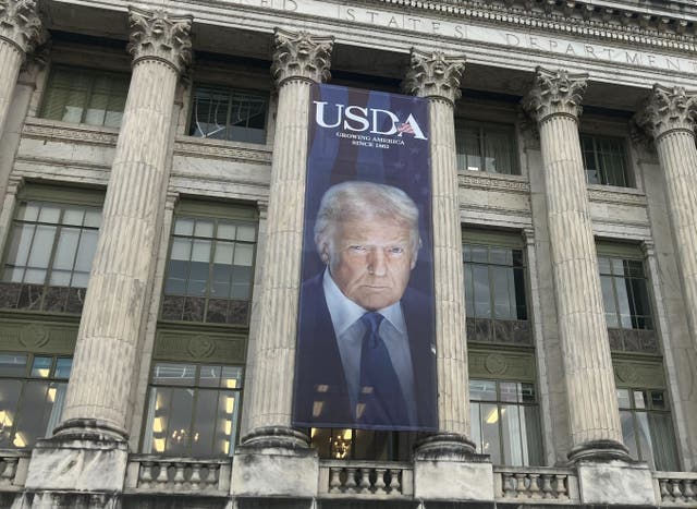 <p>A large banner depicting President Donald Trump hangs on the facade of the U.S. Department of Agriculture in Washington, D.C.  Thursday</p>