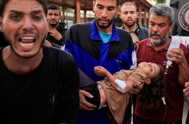 <p>A Palestinian man carries a wounded child, after the European Hospital was partially damaged following Israeli airstrikes,</p>