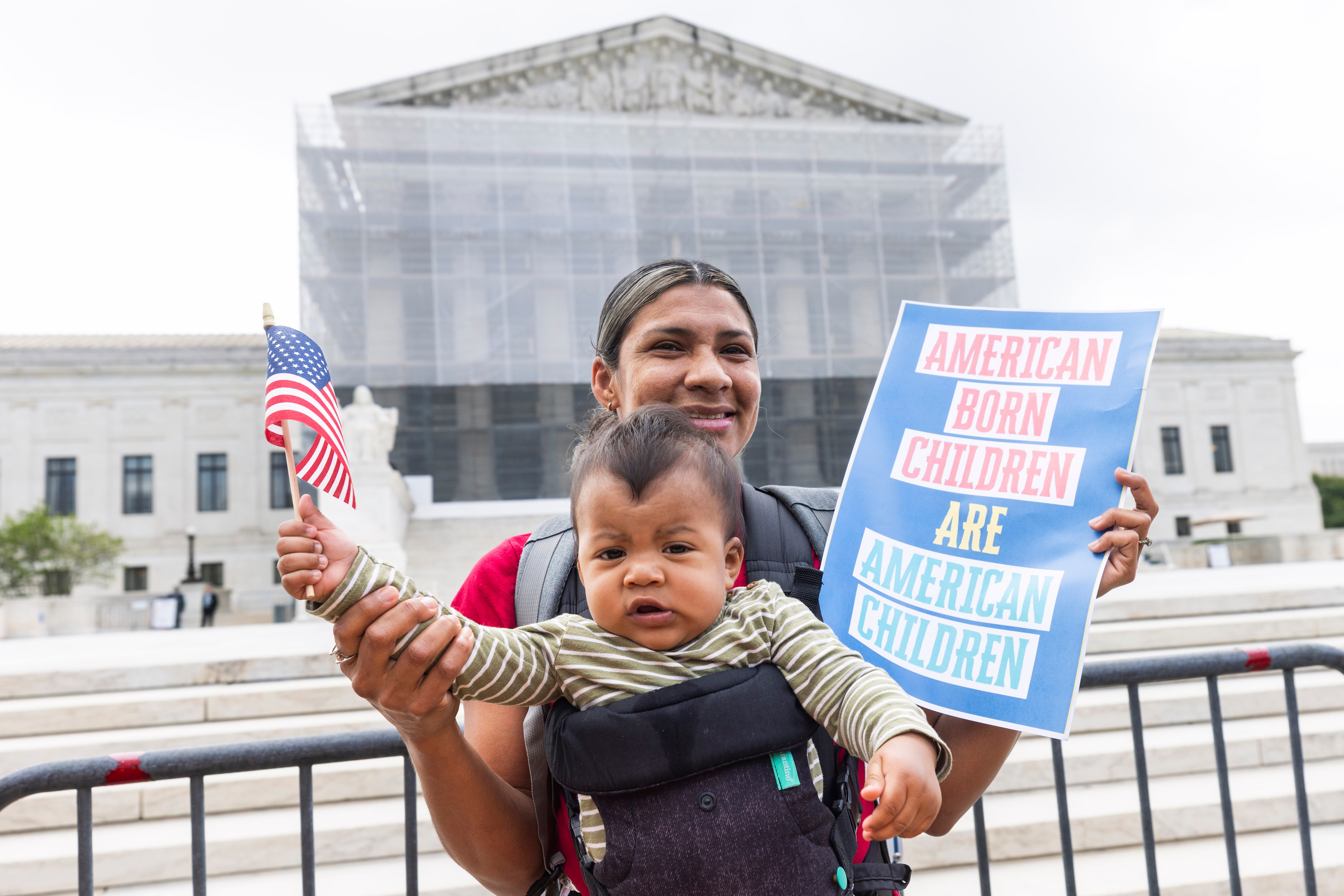 Olga Urbina and nine-month-old Ares Webster join supporters of birthright citizenship outside the Supreme Court on May 15