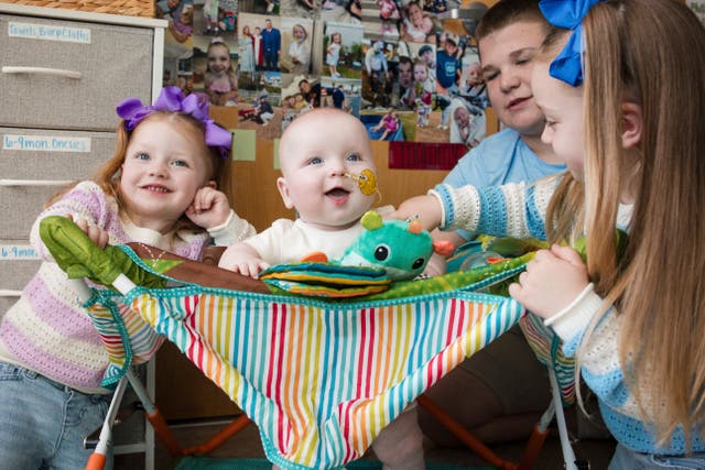<p>KJ Muldoon, center, sits with his siblings after a follow-up dose of an experimental gene editing treatment at the hospital in April 2025</p>
