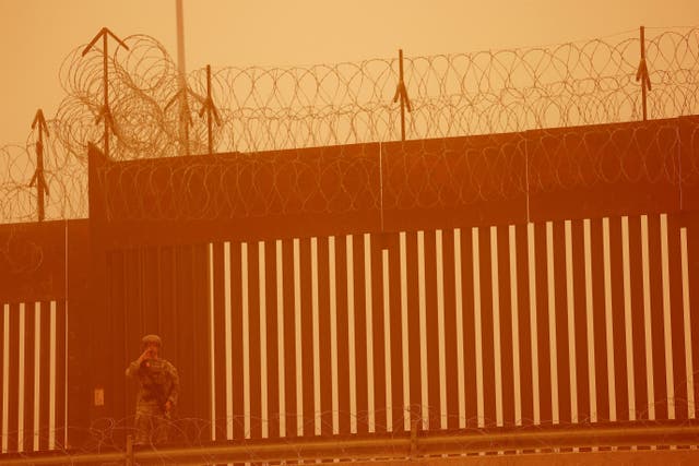 <p>A Texas National Guard soldier stands near the wall on the border between Mexico and U.S. during a sandstorm, as seen from Ciudad Juarez, Mexico March 6, 2025</p>
