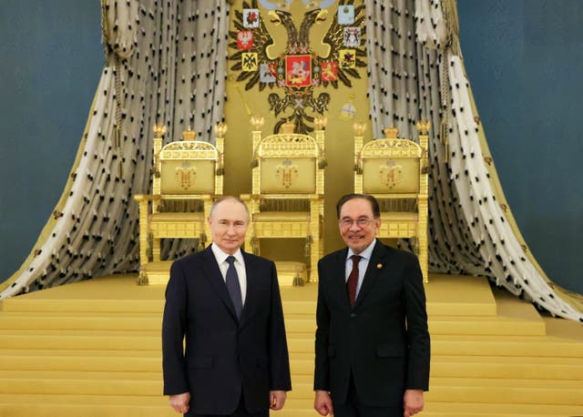 <p>Russian president Vladimir Putin and Malaysian prime minister Anwar Ibrahim pose for photos following their meeting in St Andrew's Hall of the Grand Kremlin Palace in Moscow, Russia</p>