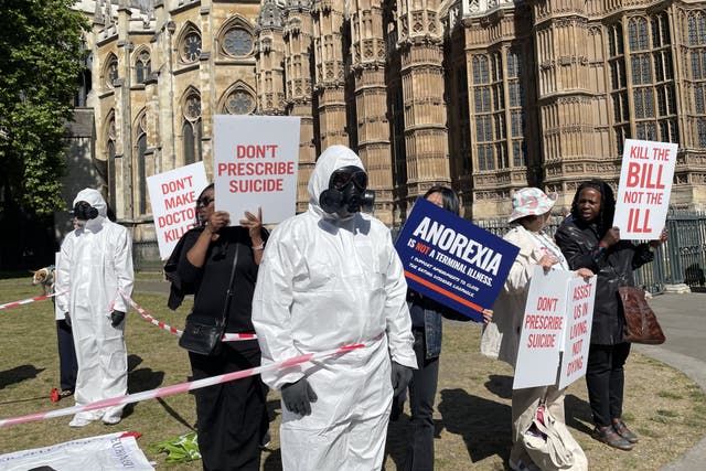 Protesters hold up signs which read ‘don’t prescribe suicide’ (Rosie Shead/PA)