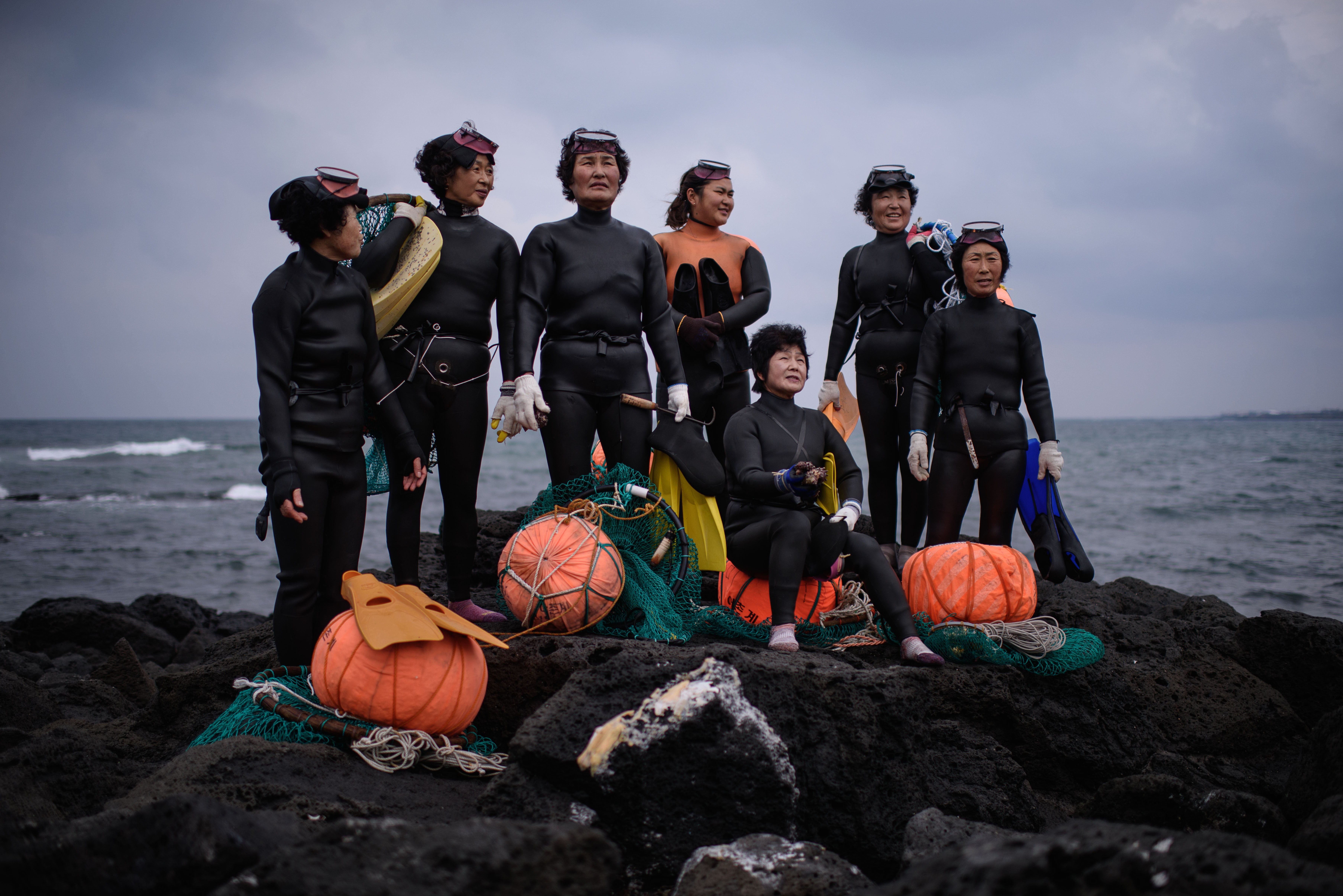 Haenyeo pose for photographers as they perform a demonstration during a media event