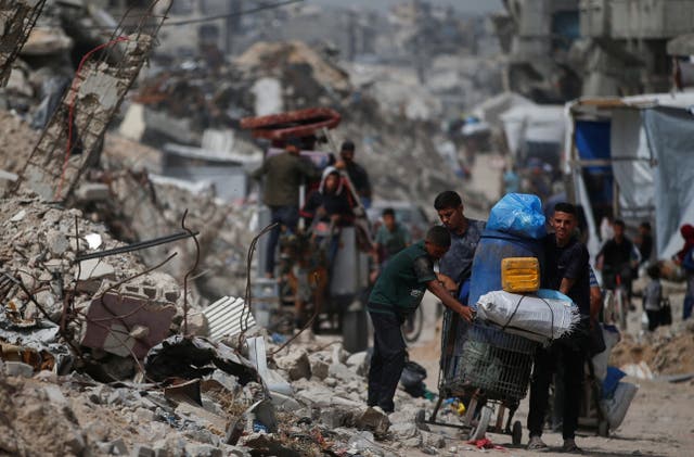 <p>Palestinians make their way with belongings as they flee their homes after Israeli airstrikes in the northern Gaza Strip on Saturday</p>