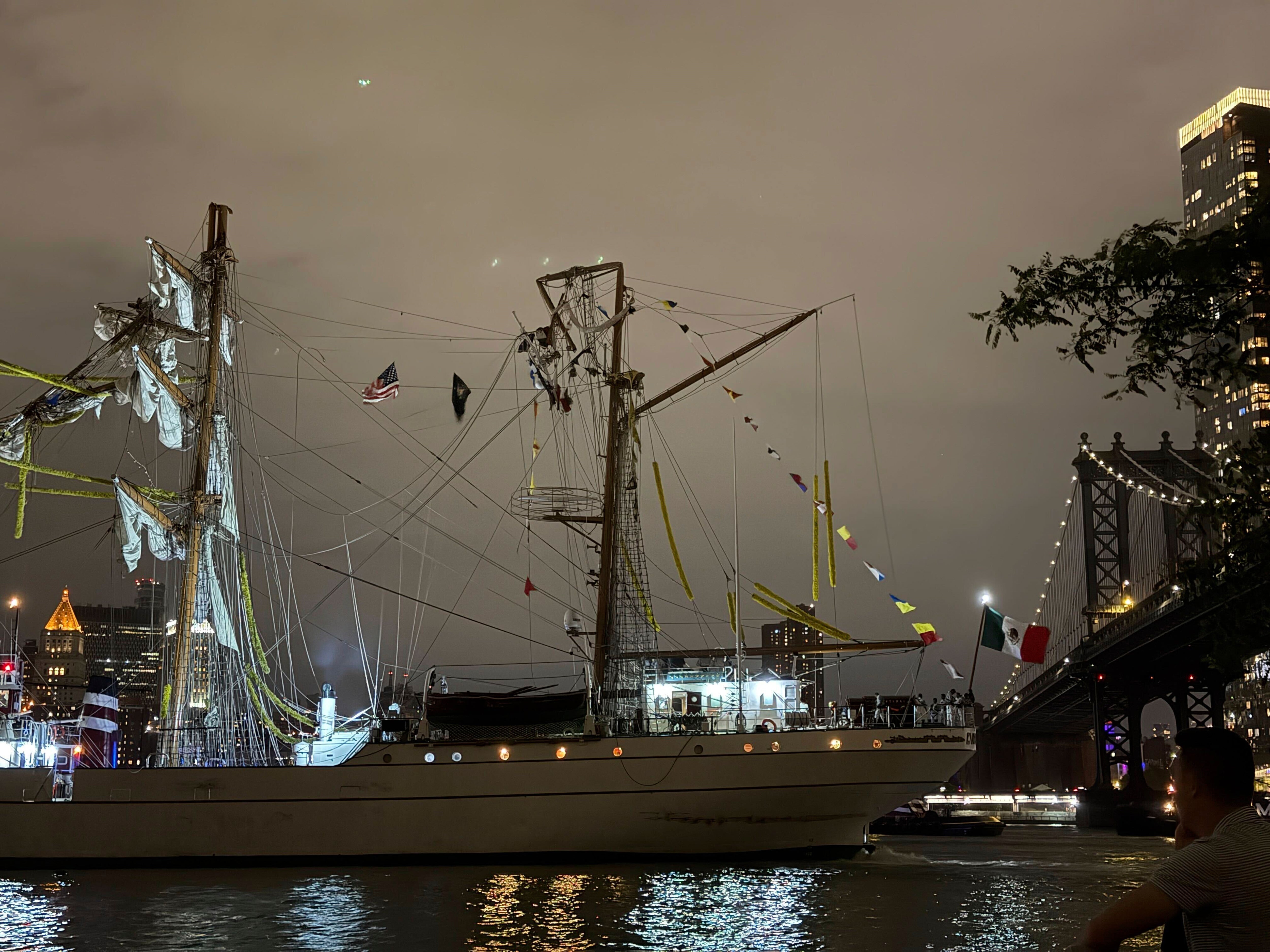 The Mexican navy ship sits in the water, its masts snapped