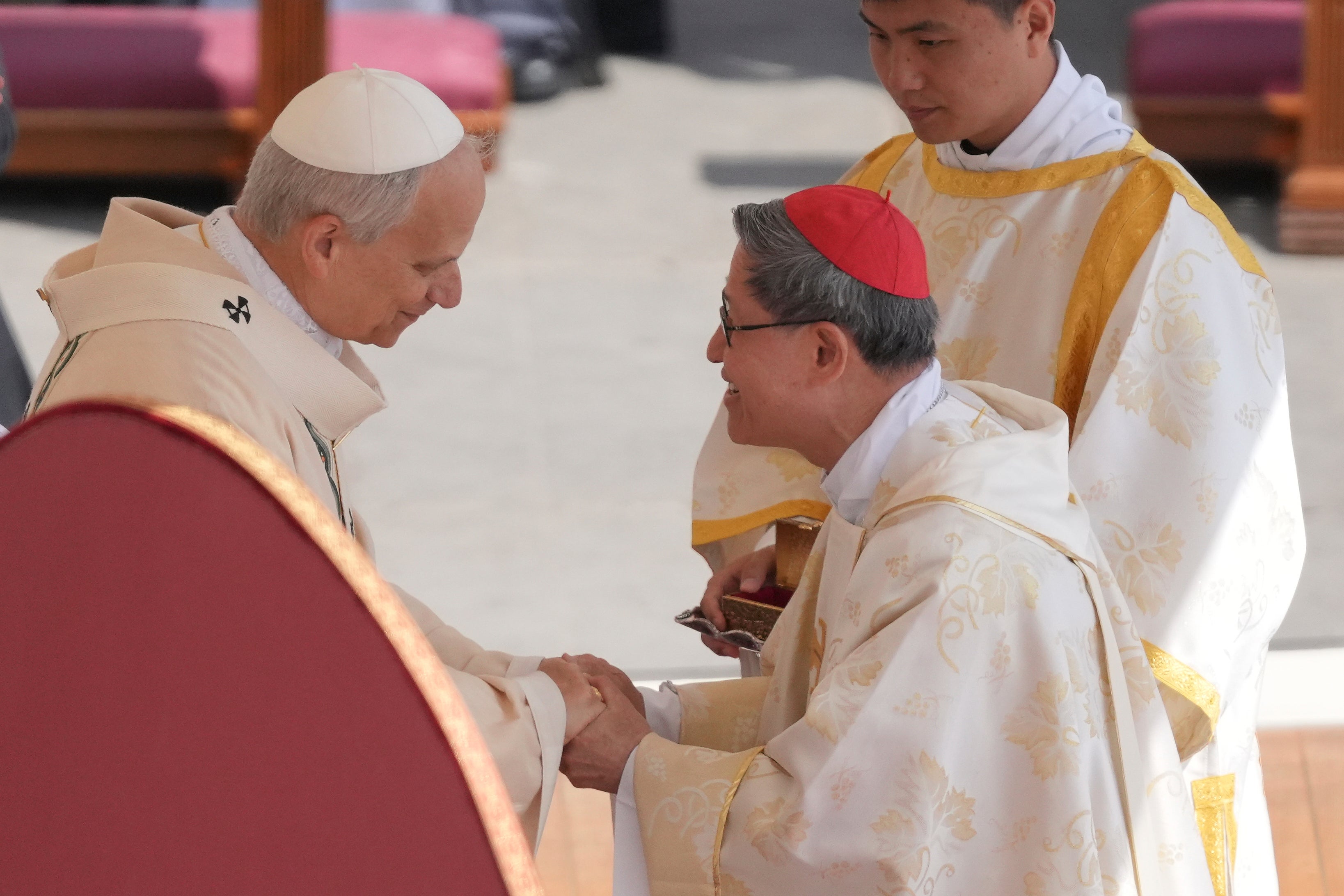 Pope Leo XIV holds hands after receiving the fisherman's ring, a symbol of the papacy, from Cardinal Luis Antonio Tagle, one of the papabile during the conclave