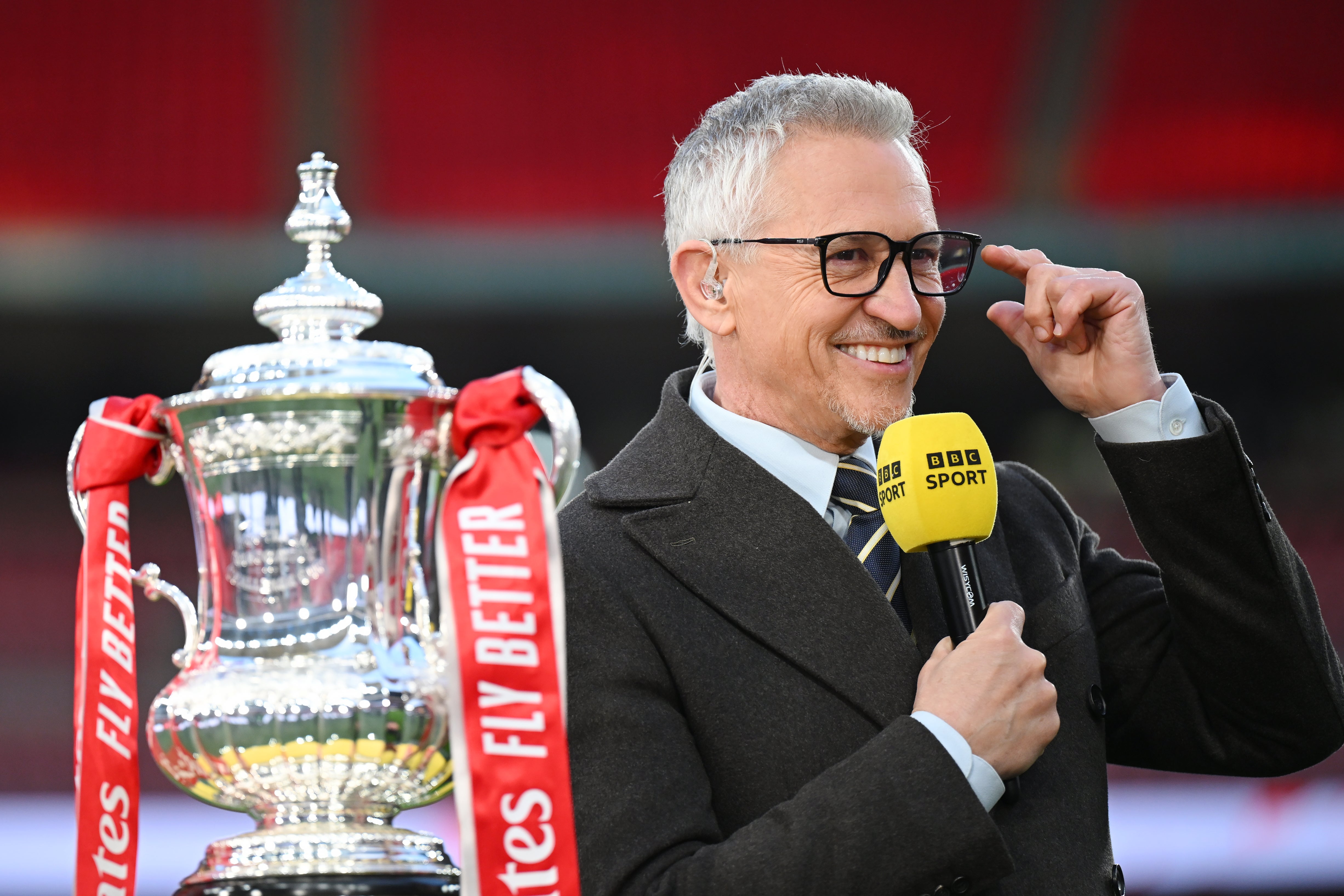 BBC presenter Gary Lineker looks on next to the FA Cup trophy