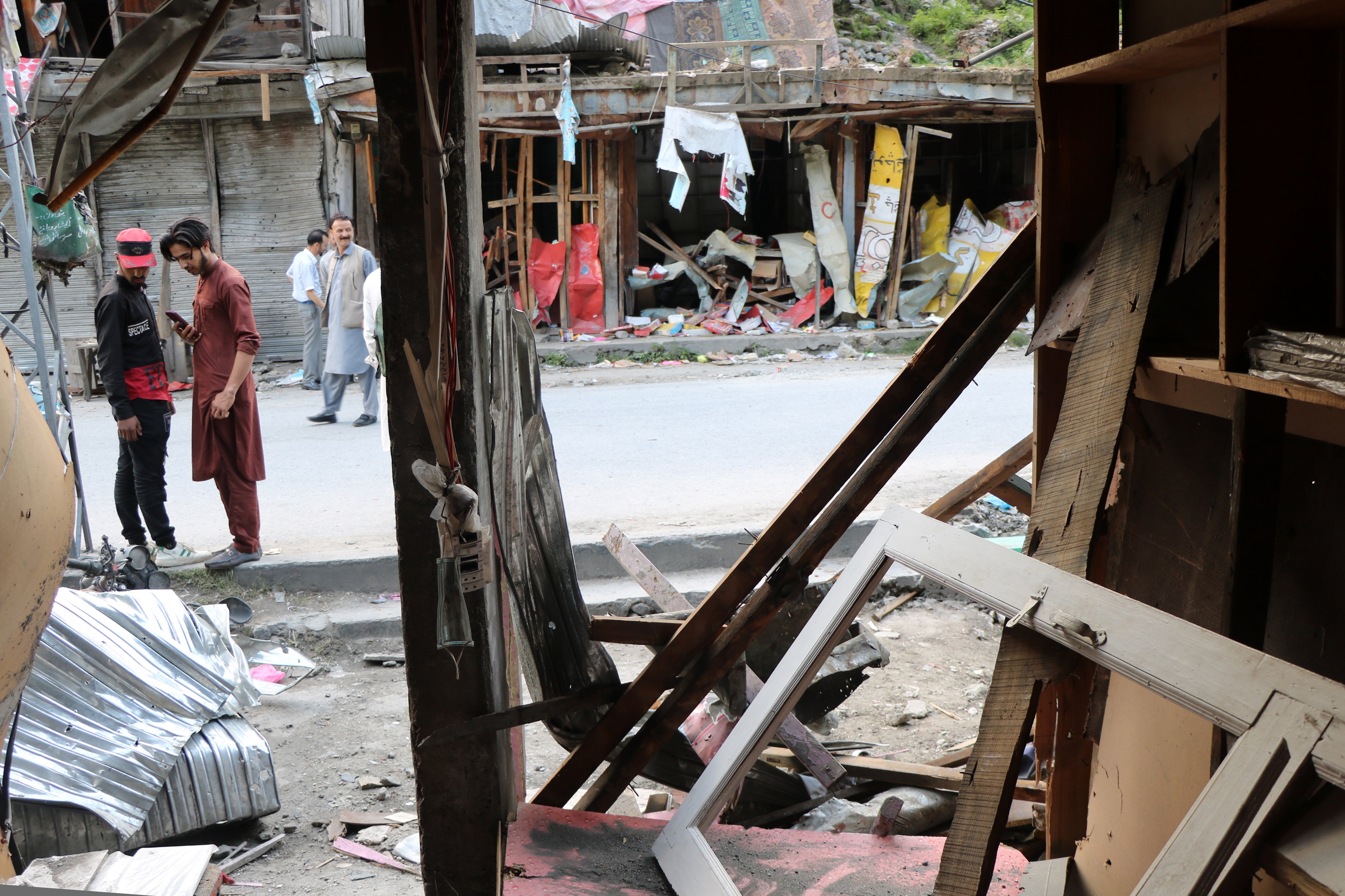 People inspect a market damaged by Indian shelling in Jura village of Neelum Valley