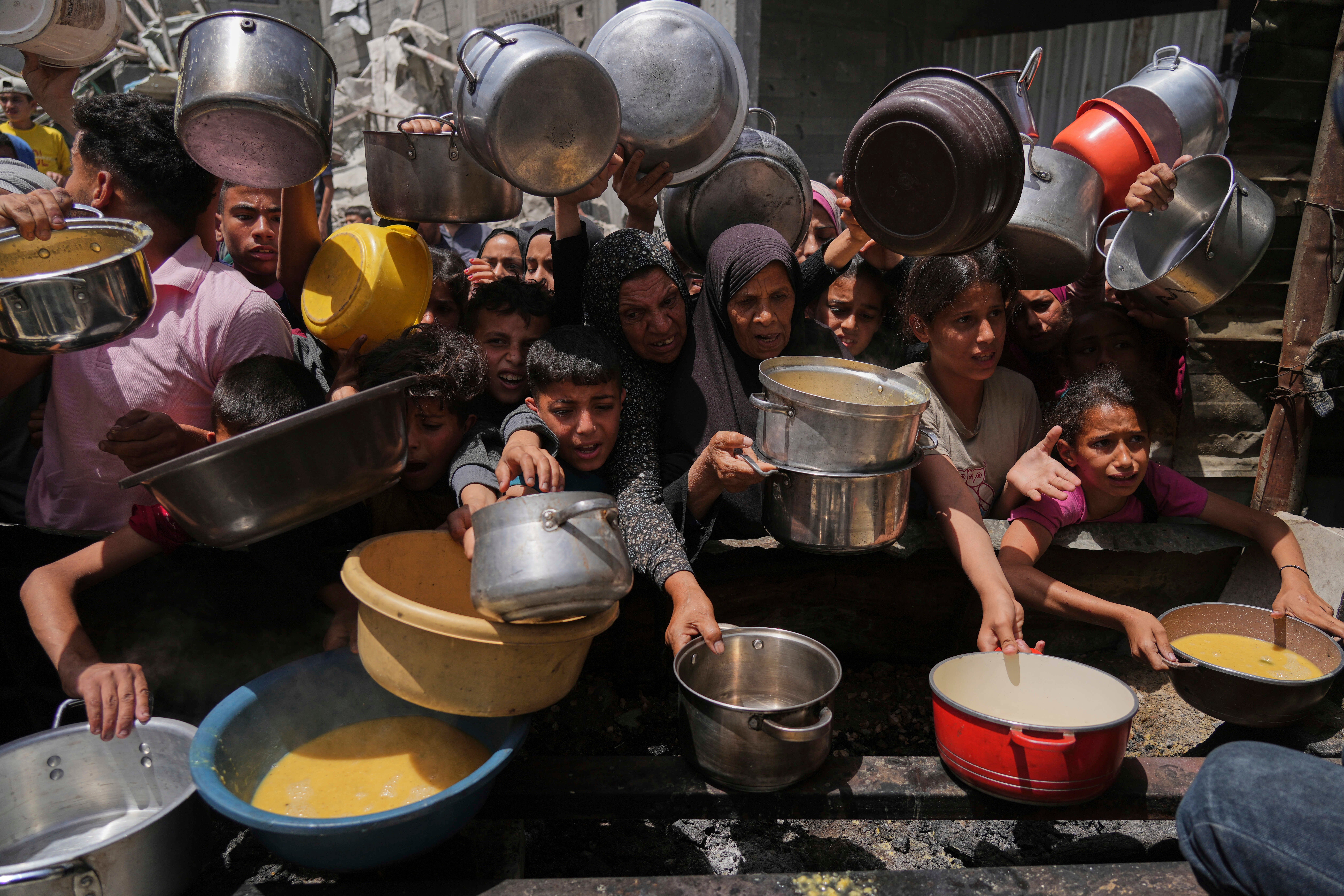 Palestinians struggle to get donated food at a community kitchen in Jabalia, northern Gaza Strip on Monday