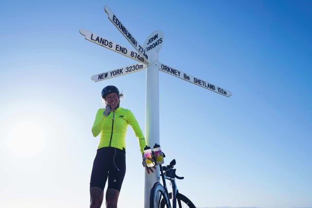 <p>Sarah Ruggins, who has complex regional pain syndrome, at John O’Groats after completing her cycling challenge </p>