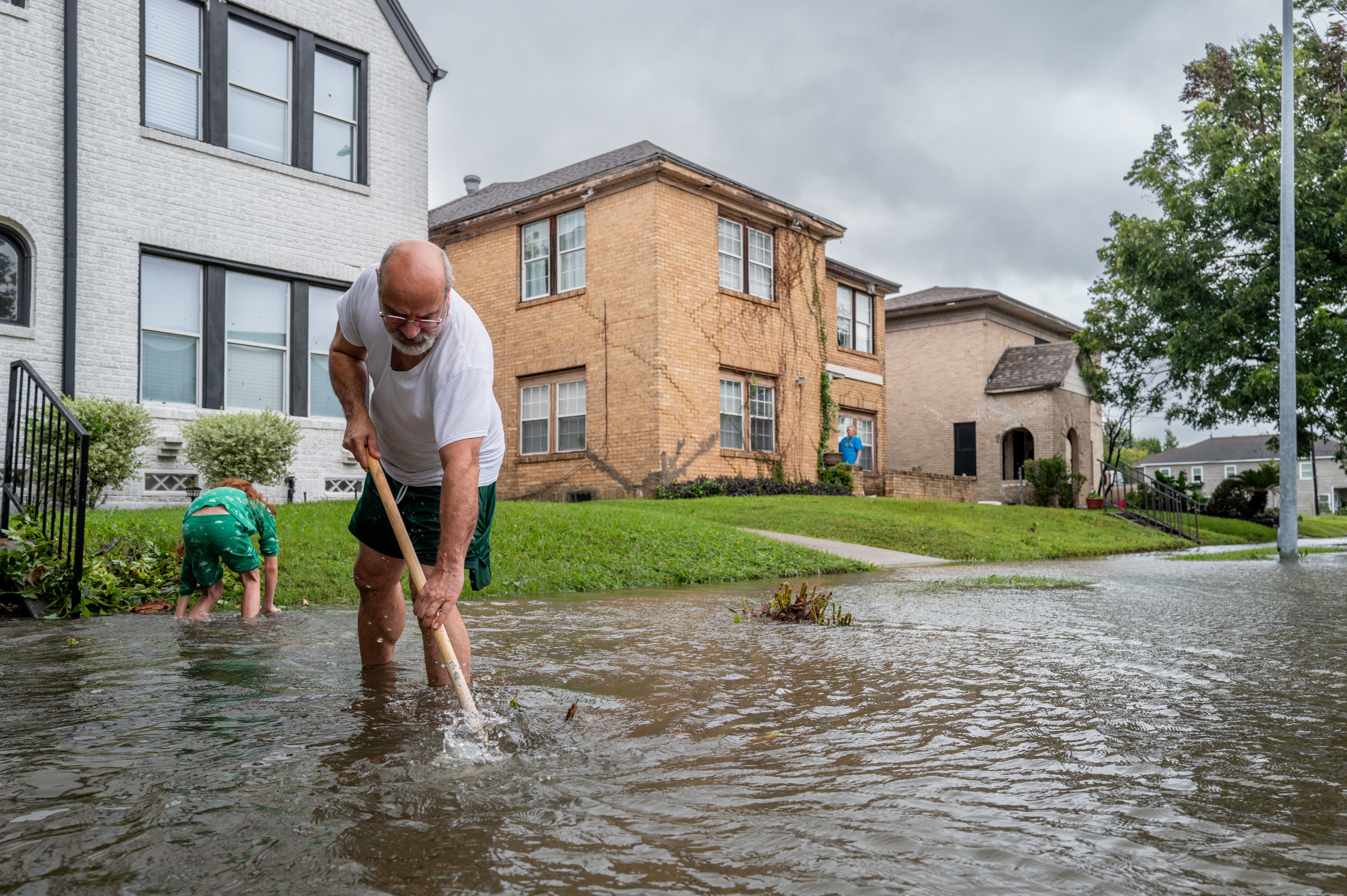 Jack Reyna and his son work to drain floodwater in their neighborhood after Hurricane Beryl swept through the area on July 08, 2024 in Houston, Texas.