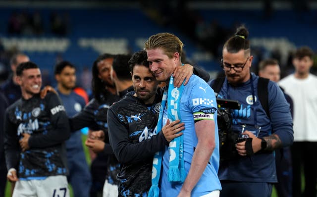 <p>Kevin De Bruyne is embraced by Bernardo Silva after his farewell game at the Etihad Stadium</p>