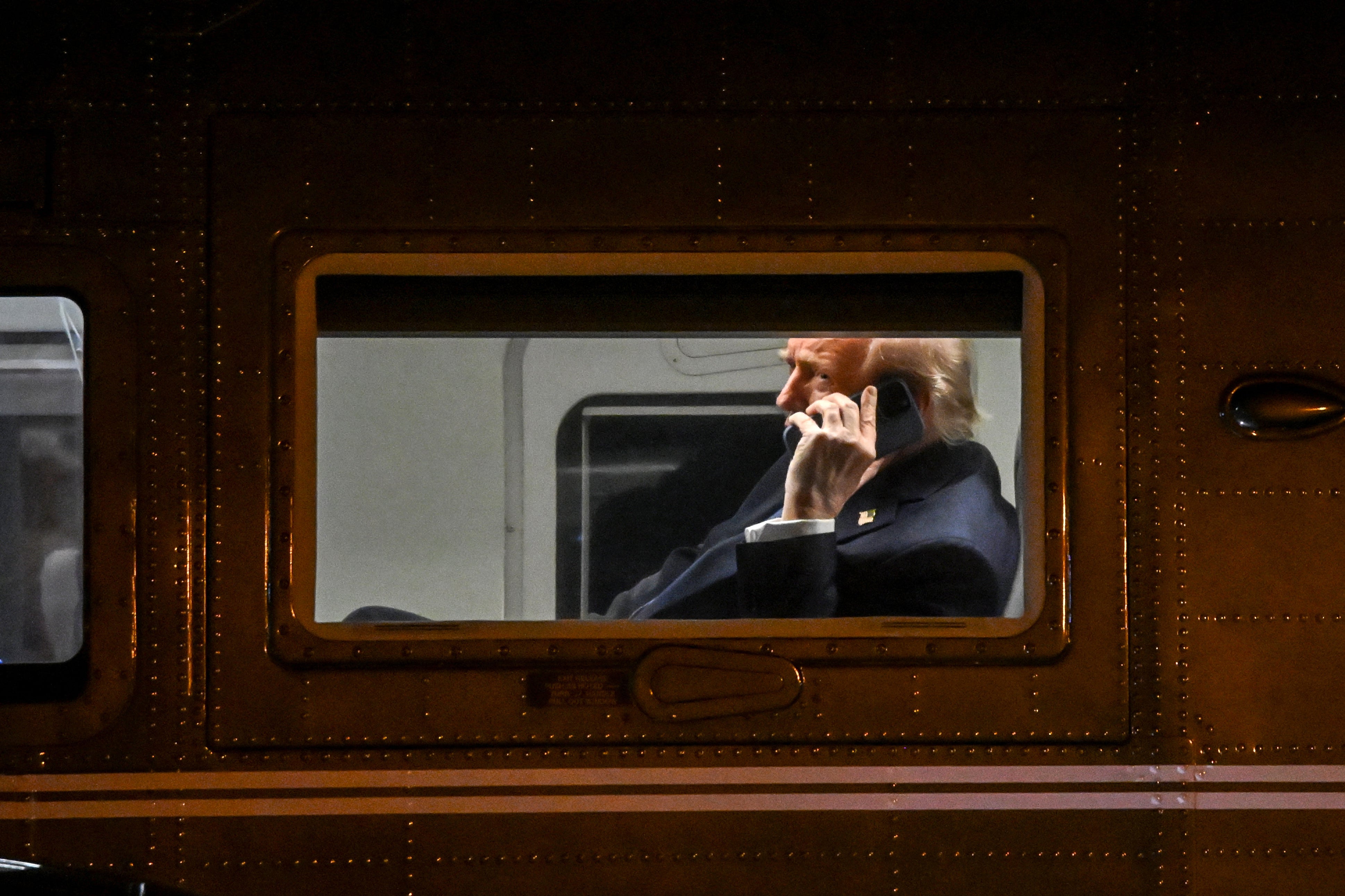 US President Donald Trump uses a cell phone on board Marine One