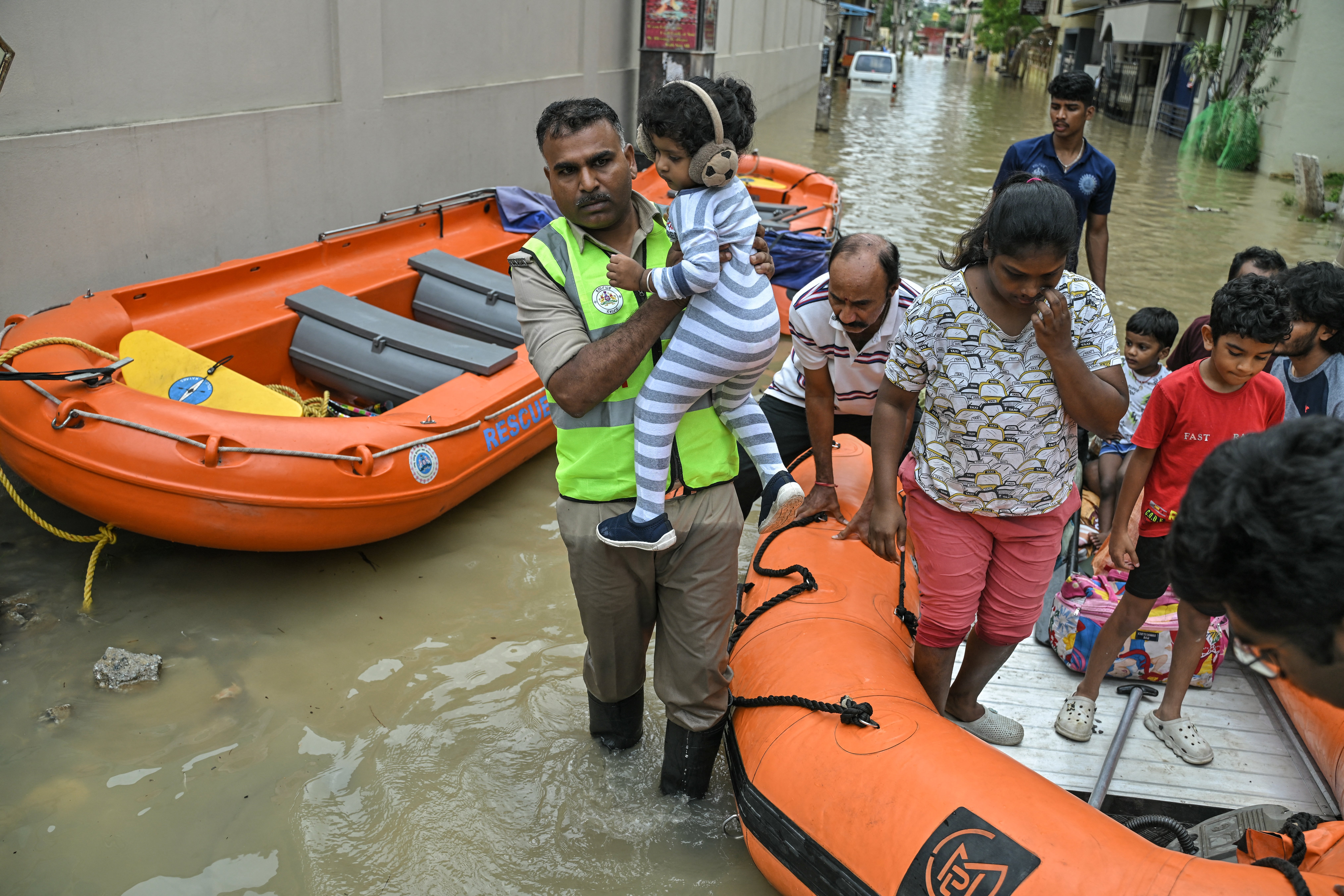 <p>State Disaster Response Force (SDRF) personnel rescue residents from a flooded locality following heavy rainfall in Bengaluru on 19 May 2025</p>