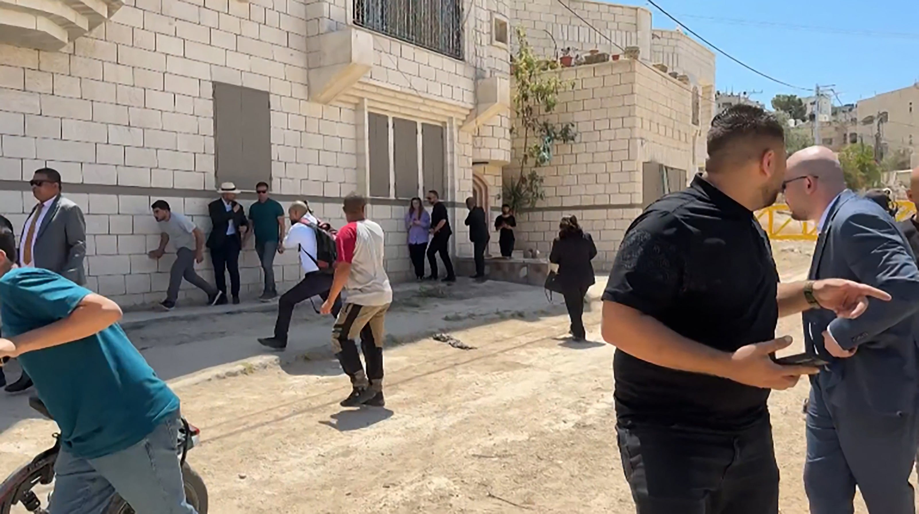 This frame grab from AFPTV footage shows members of a diplomatic delegation from the European Union reacting after shots were fired as they gathered in the eastern entrance of Jenin camp