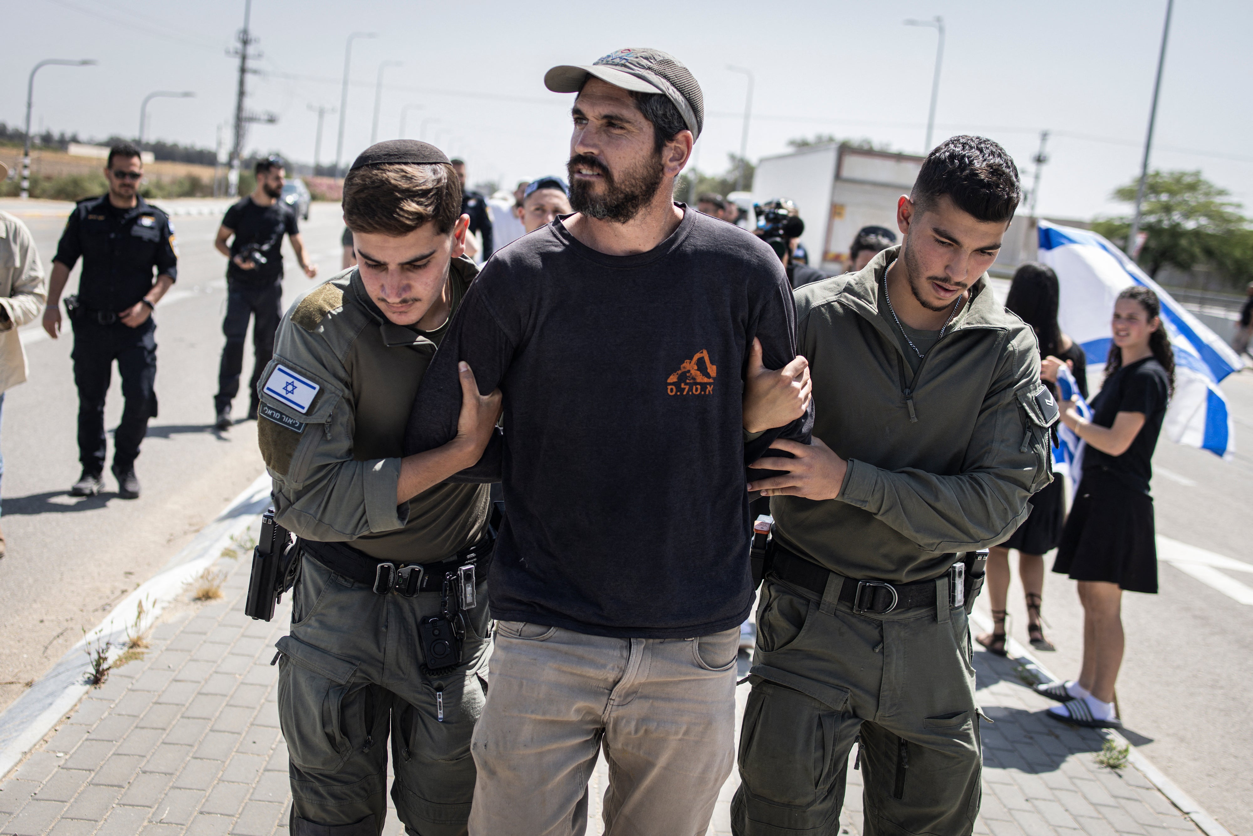 Israeli security forces detain a man during an attempt by right-wing protesters to block aid trucks from entering Gaza at the Kerem Shalom crossing