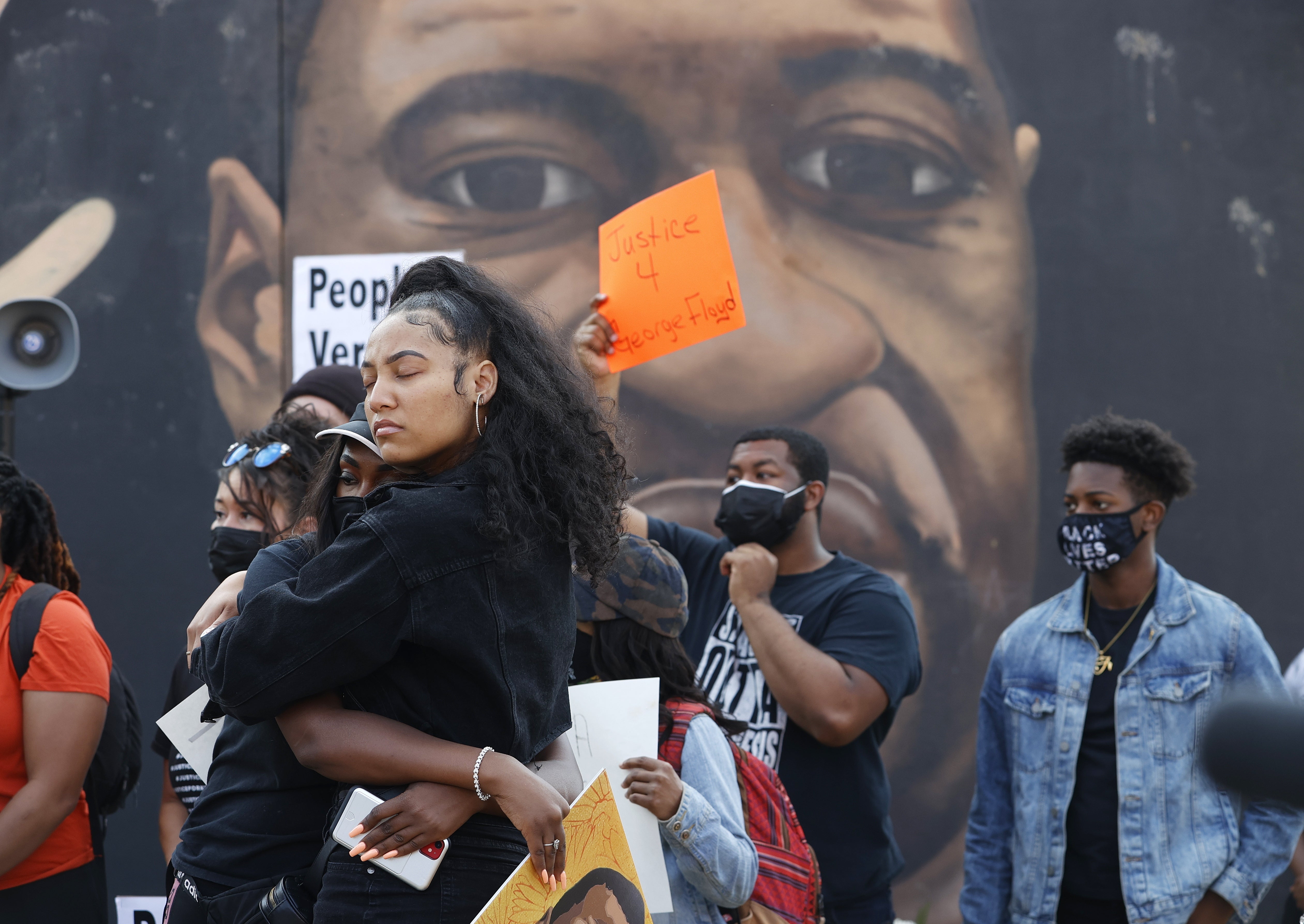 Demonstrators stand by a mural of George Floyd after former Minneapolis Police Department officer Derek Chauvin was found guilty of his murder on April 20, 2021