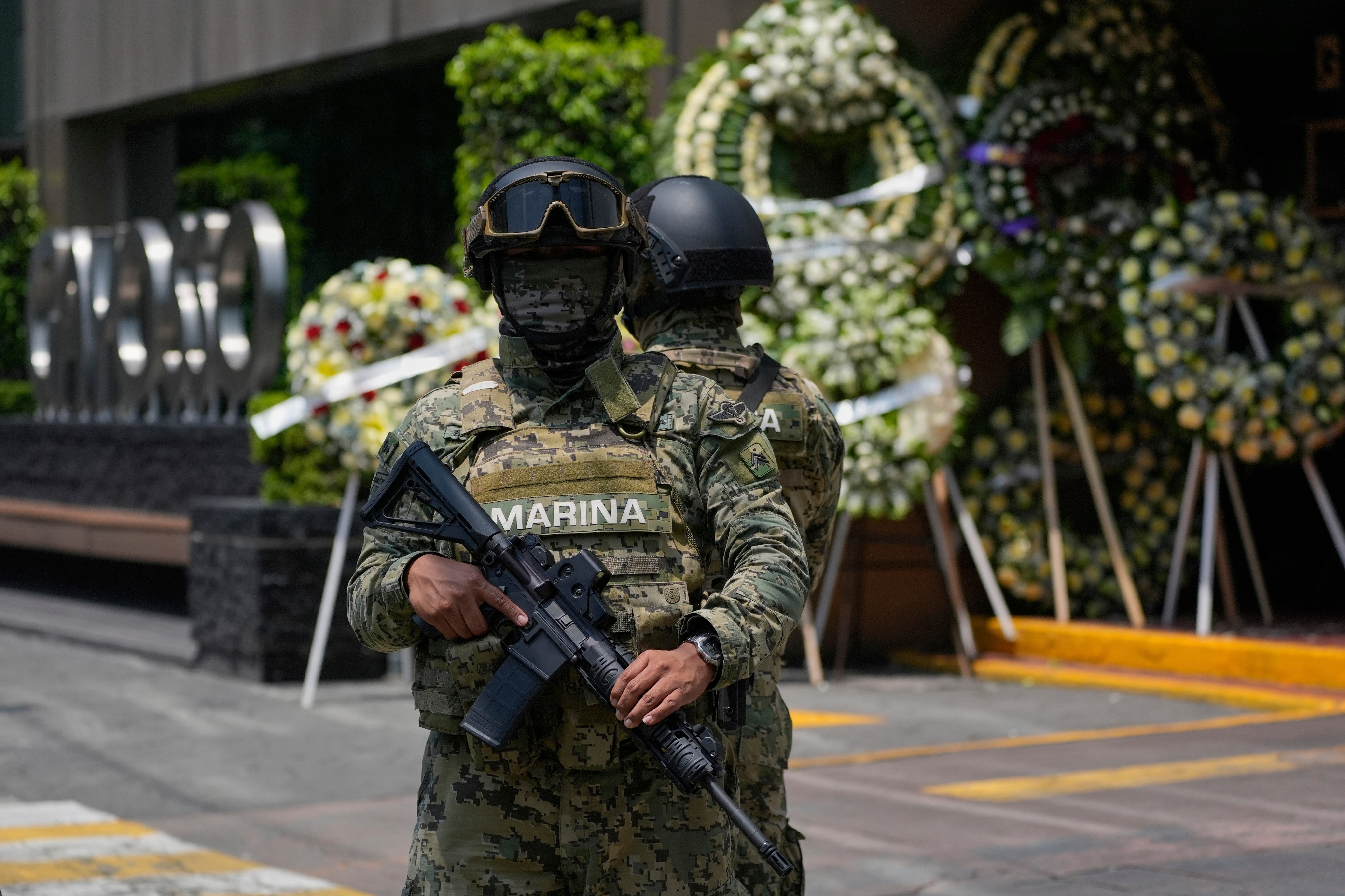 Navy soldiers stand guard outside the funeral home where the remains of Ximena Guzmán, the personal secretary of the Mexico City mayor, and advisor to the mayor, José Muñoz, are being held, in Mexico City, Wednesday, May 21, 2025. (AP Photo/Marco Ugarte)