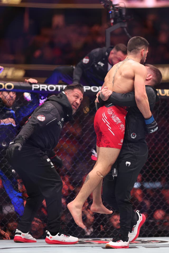 <p>Ilia Topuria is congratulated by his coaches after winning the UFC featherweight title</p>