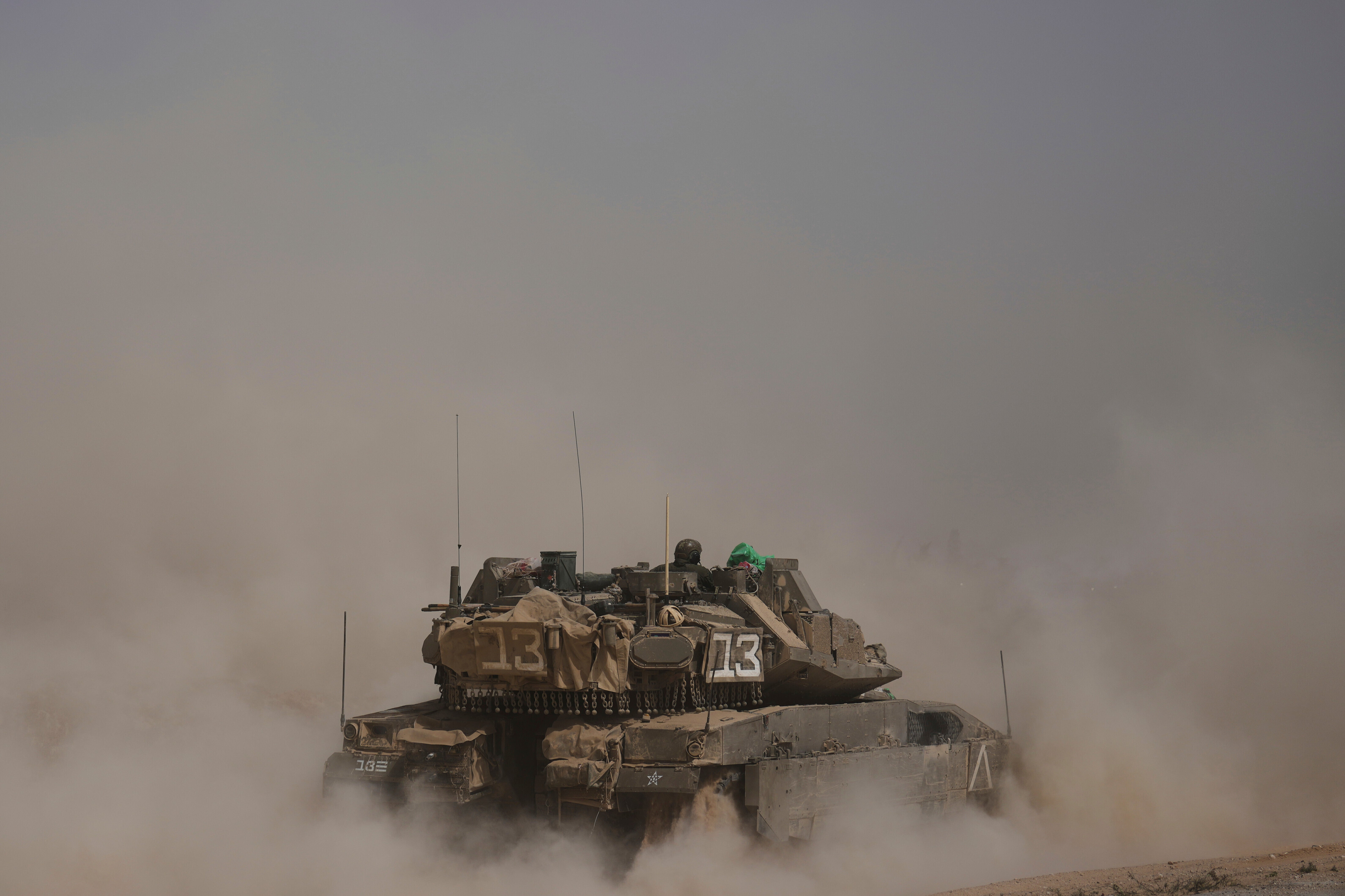 Israeli soldiers move tanks around a staging area near the border with the Gaza Strip in southern Israel