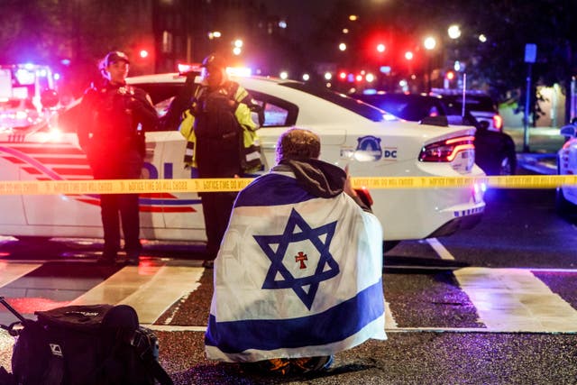<p>A man with an Israeli flag draped on his shoulders near the scene where two people were shot and killed near the Capital Jewish Museum in Washington</p>