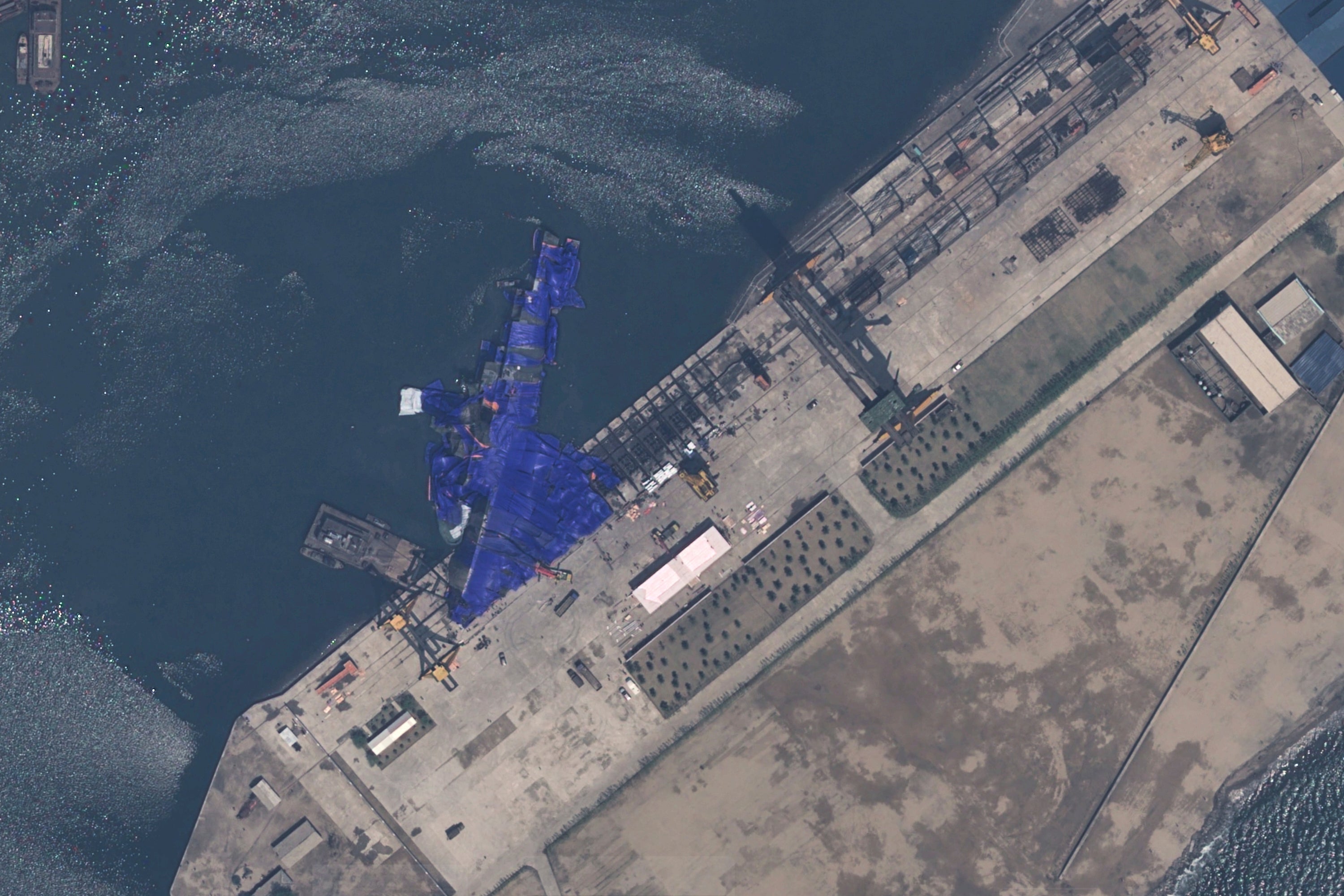 Satellite image provided by Airbus DS shows a blue tarp covering a North Korean destroyer after it suffered a failed launch in Chongjin