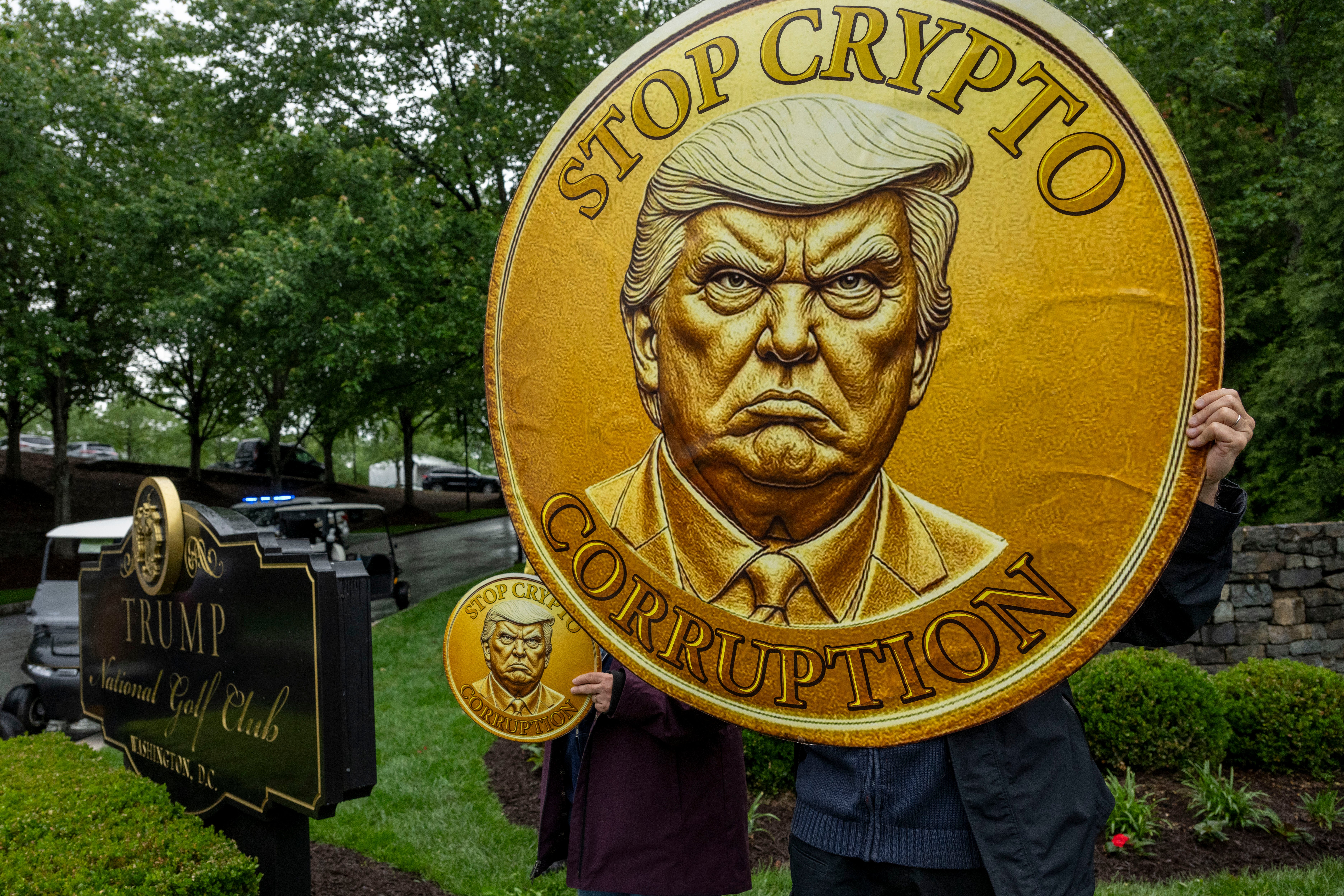 Demonstrators held signs reading ‘Stop Crypto Corruption,’ ‘America is not for sale,’ as well as a large gold coin featuring a large image of the president’s scowling face