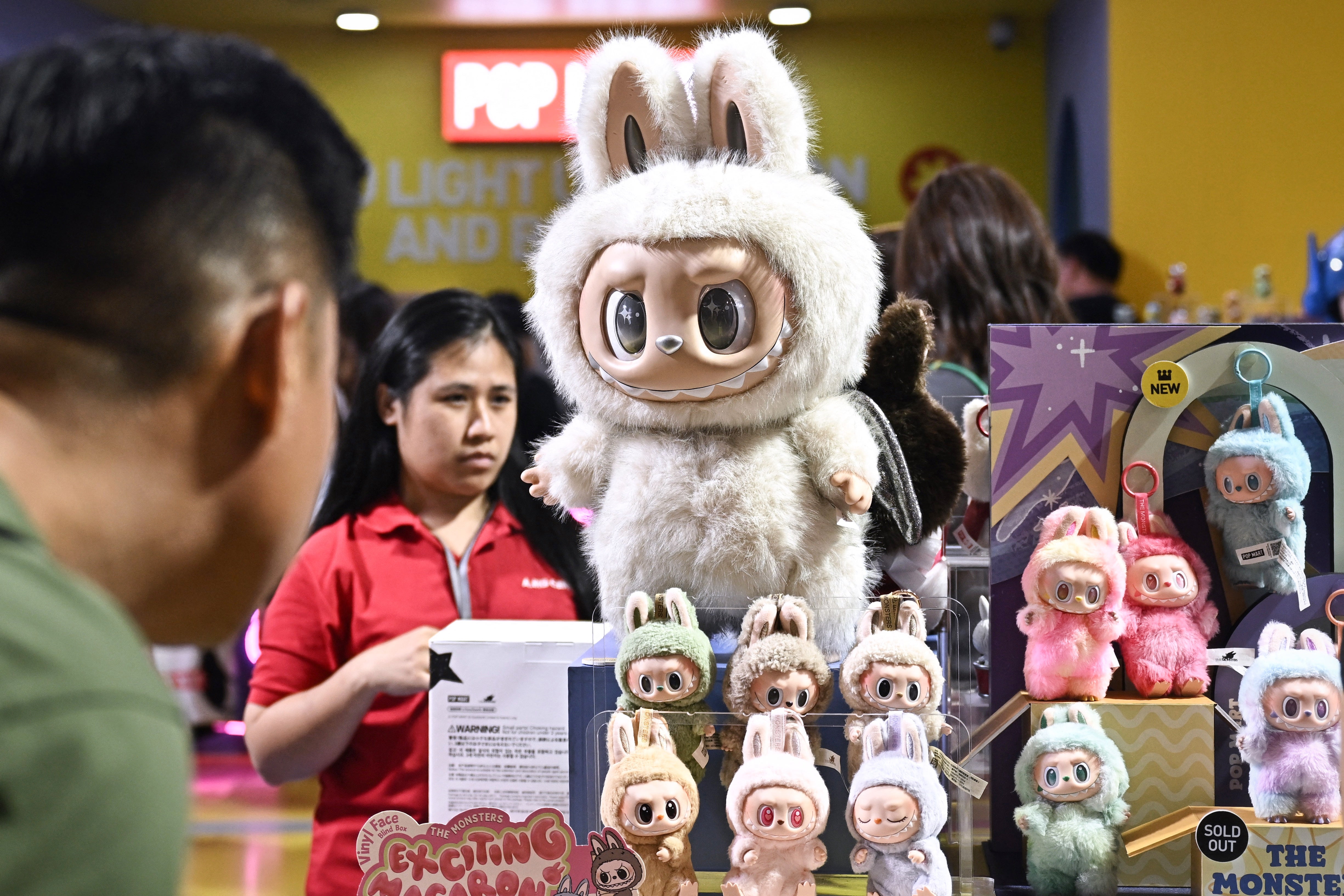 <p>People look at Labubu toys at a Pop Mart pop-up store in Bangkok</p>