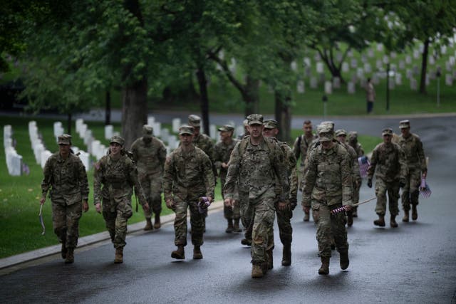 <p>Service members carry US flags at Arlington National Cemetery during the Annual Flags-In Ceremony in Arlington, Virginia, on May 22, 2025</p>