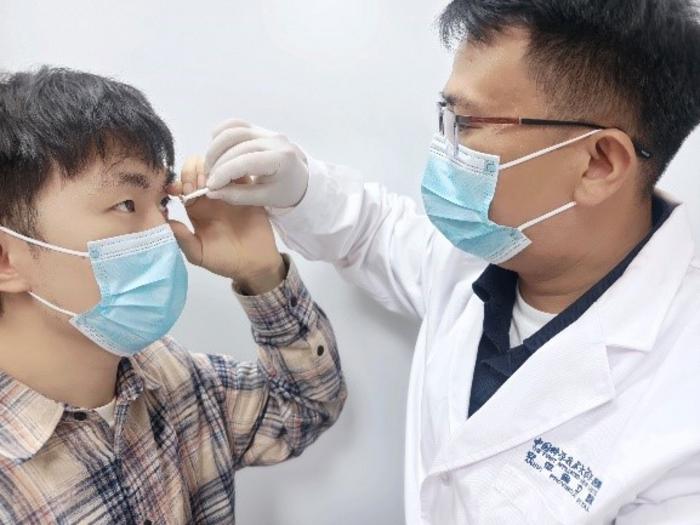 Researcher places infrared contacts in participant's eyes