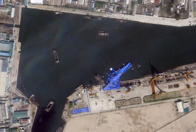 <p>Satellite image shows a North Korean warship covered with blue tarp after an accident during its launch at the shipyard in Chongjin</p>