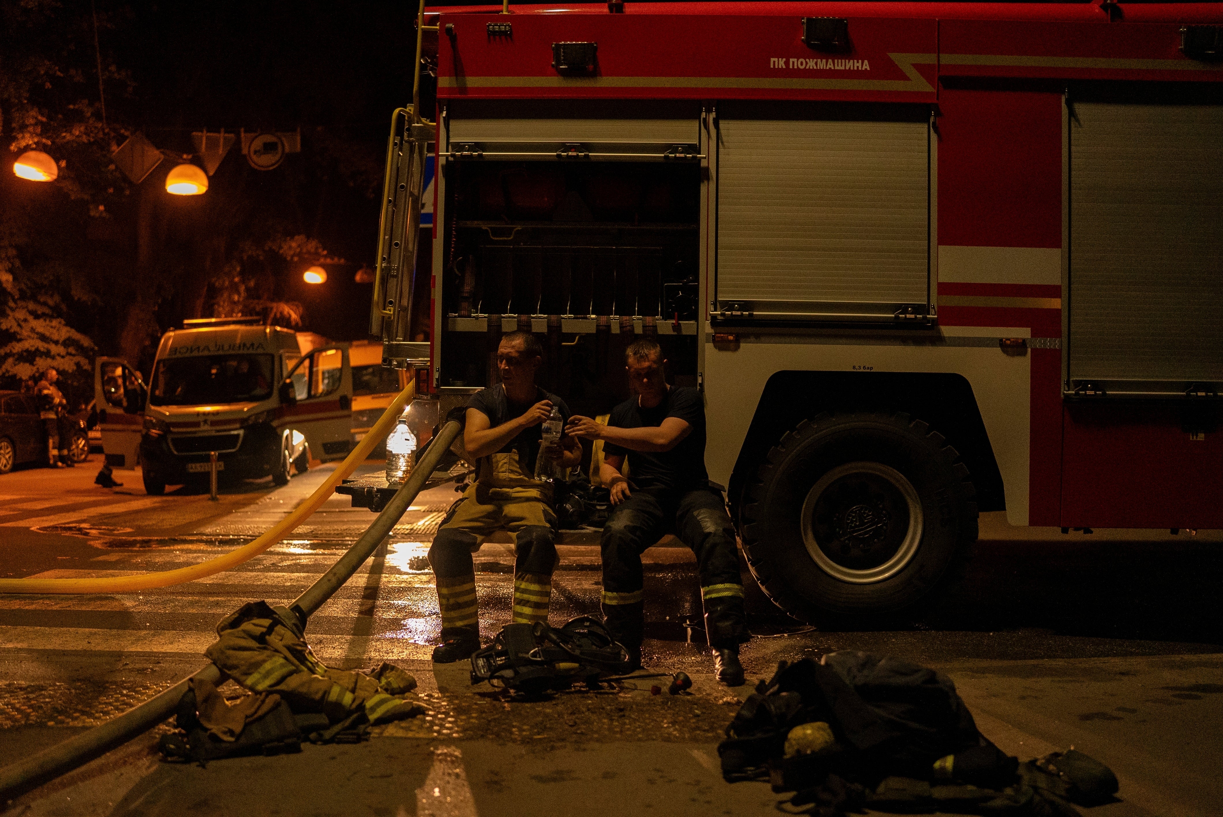 Firefighters pass water to each other after a Russian attack in Kyiv