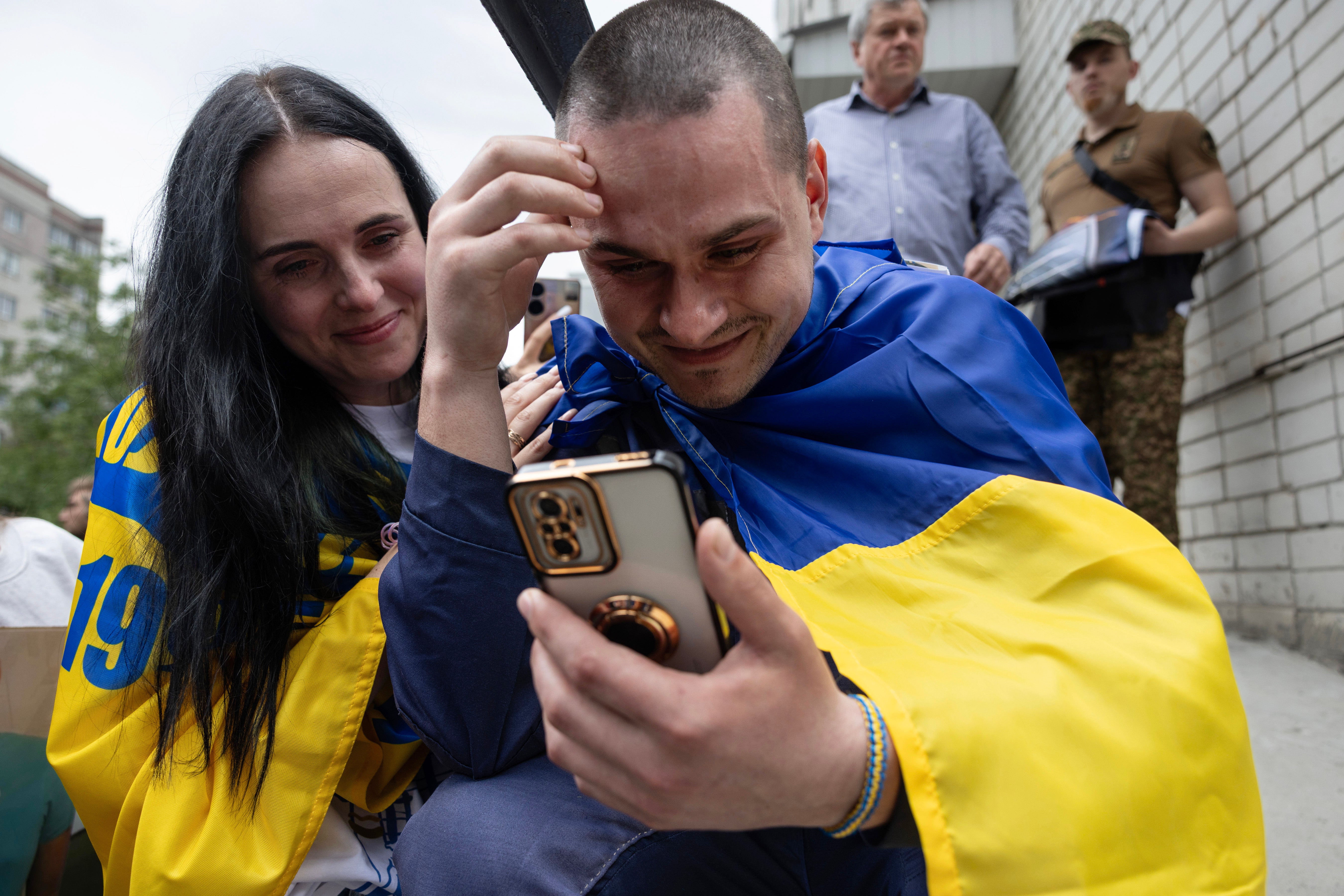 Ukrainian prisoners of war Yuriy Yuzvyak shares a happy moment with his wife Olena talking to his two children as he returns after months in a Russian prison