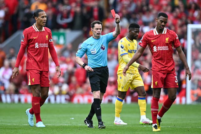 <p>Referee Darren England gives a red card to Liverpool's Dutch midfielder Ryan Gravenberch</p>