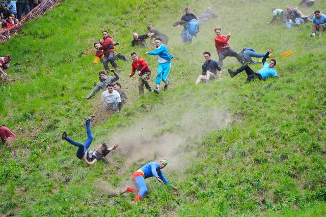 Participants take part in the annual cheese rolling at Cooper’s Hill in Brockworth, Gloucestershire (Ben Birchall/PA)