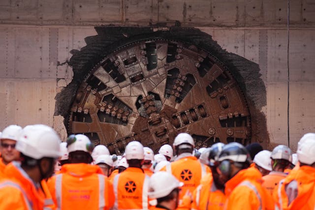 <p>HS2 workers watch a boring machine breaking through (Jacob King/PA)</p>
