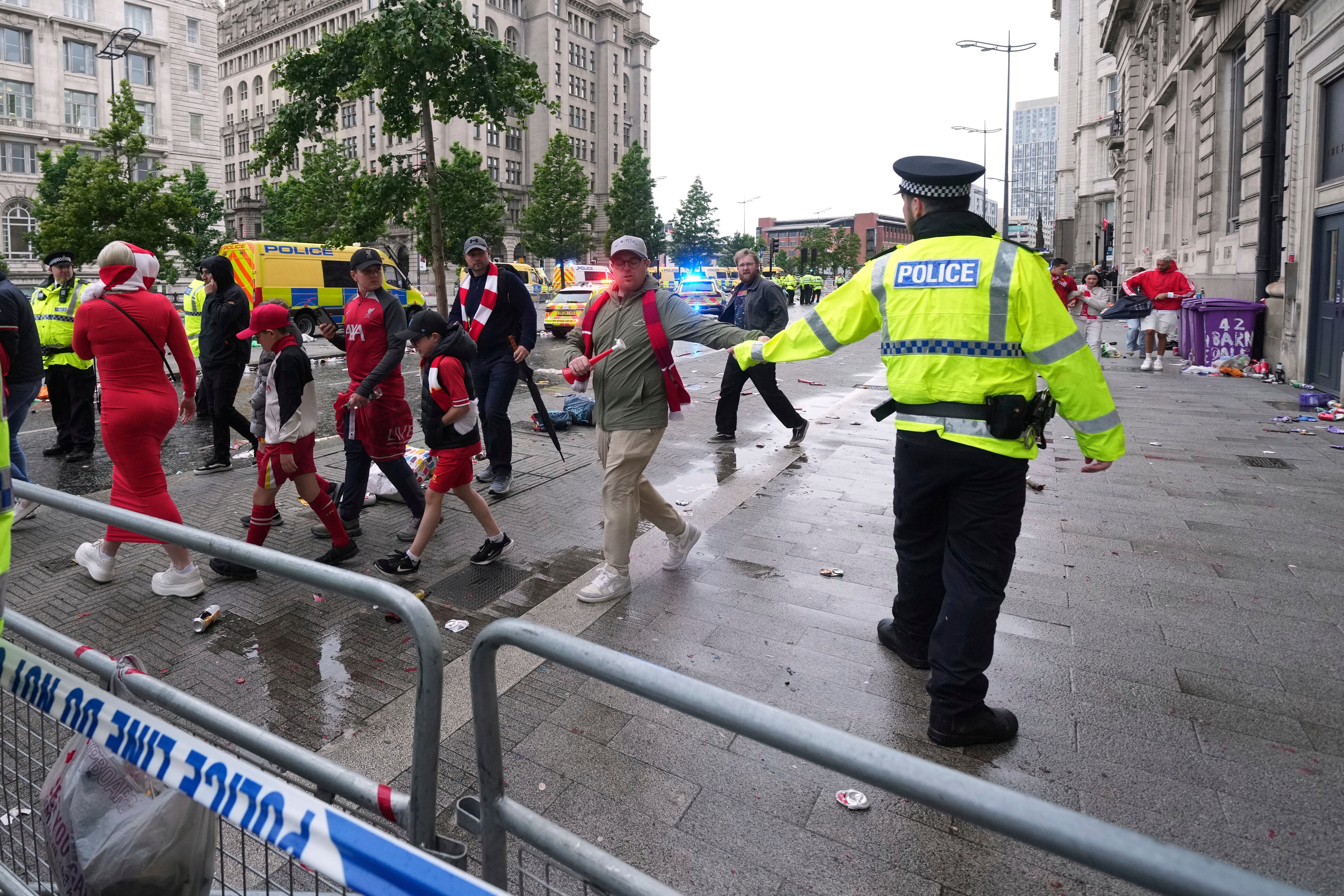 Fans leave as Police and emergency personnel deal with an incident near the Liver Building during the Premier League winners parade in Liverpool, England, Monday, May 26, 2025