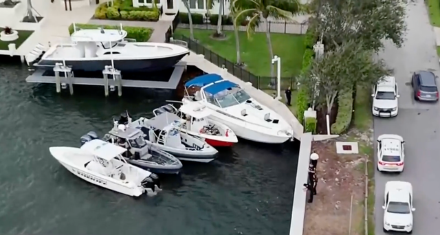 <p>Investigators examine a boat, dockside with blue cover, whose engine exploded with 13 people on board in Fort Lauderdale, Florida, </p>