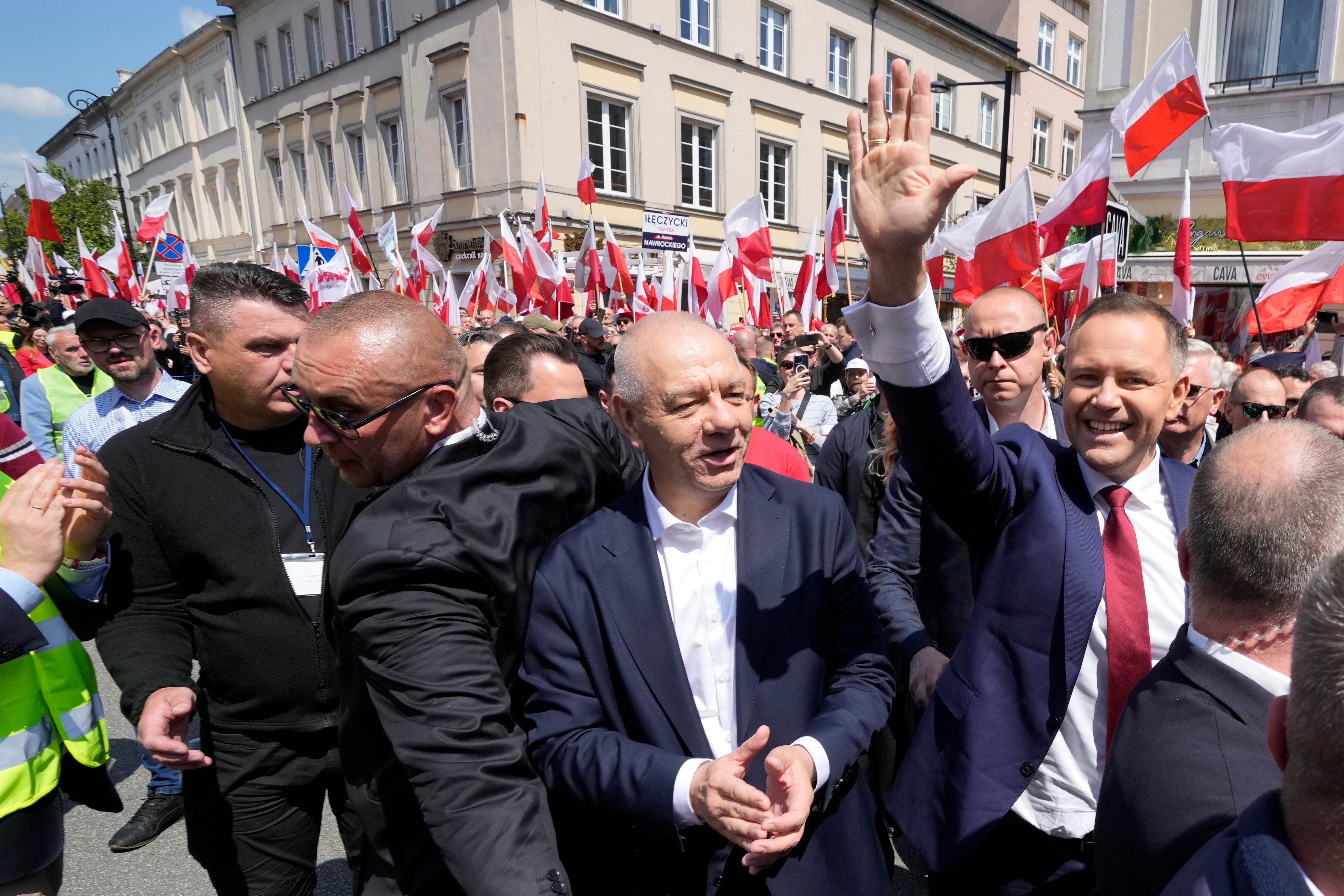 Karol Nawrocki, right, waves as he takes part in a march one week ahead of a decisive election in Warsaw Poland on Sunday