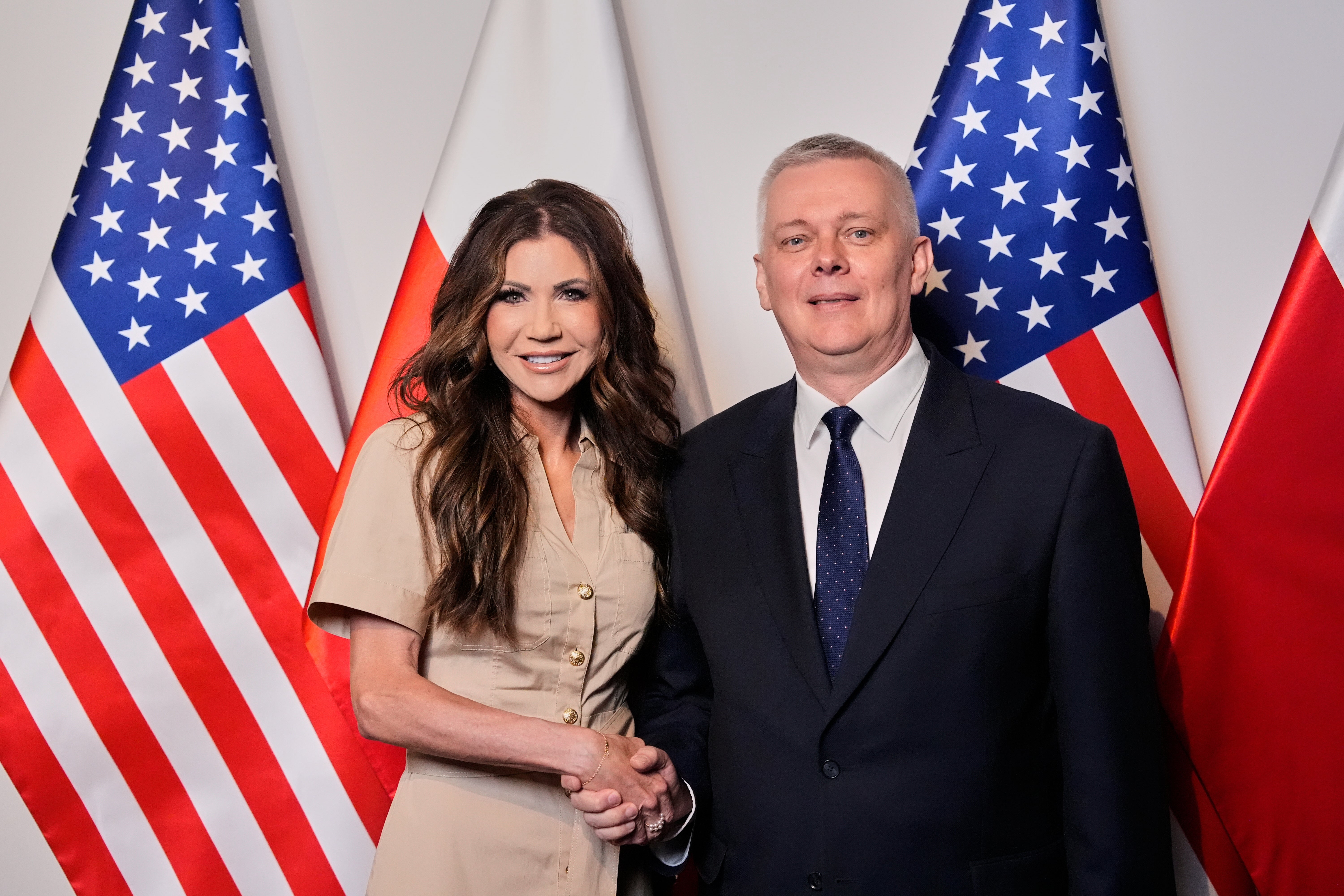 Homeland Security Secretary Kristi Noem (L) shakes hands with Polish Interior Minister Tomasz Siemoniak