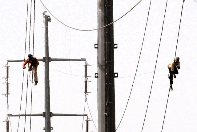 <p>Pakistani technicians work on high voltage power lines in Karachi on 11 August, 2009</p>